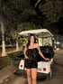Model wearing Stylera Luna high waisted shorts black sequins with strapless top by golf cart at night