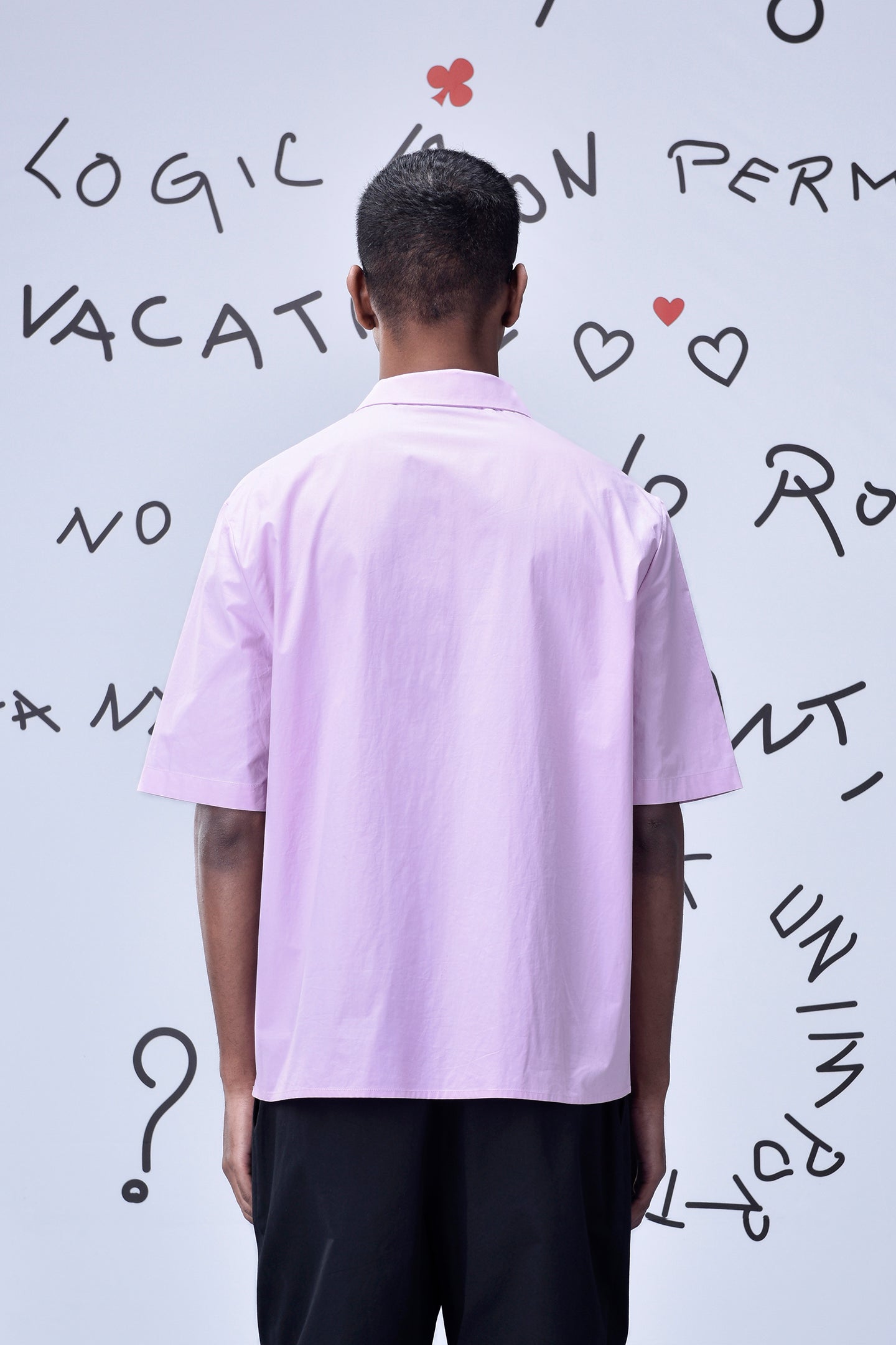 Back view of pink relaxed fit shirt for men by Stylera worn with black pants