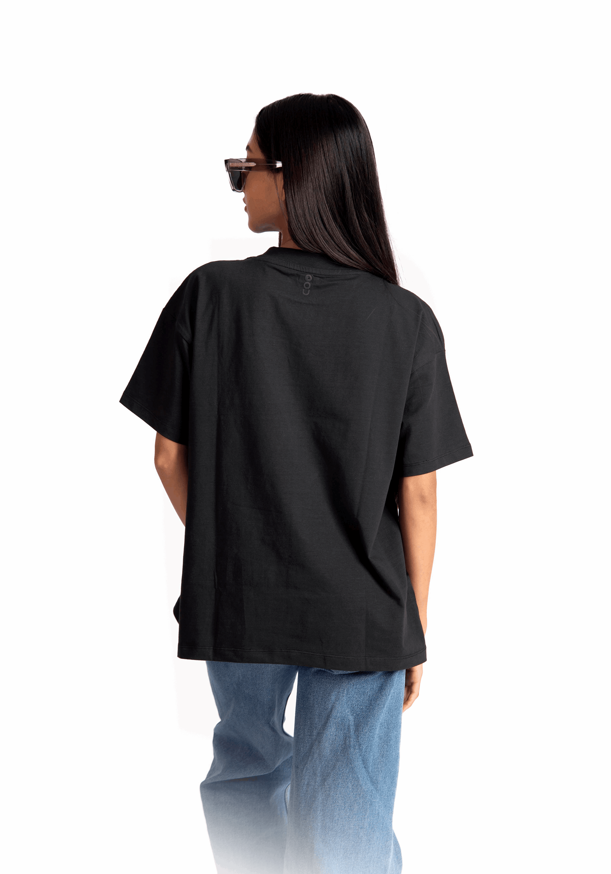 Stylera women's relaxed fit black tee shown from the back worn with blue jeans and sunglasses
