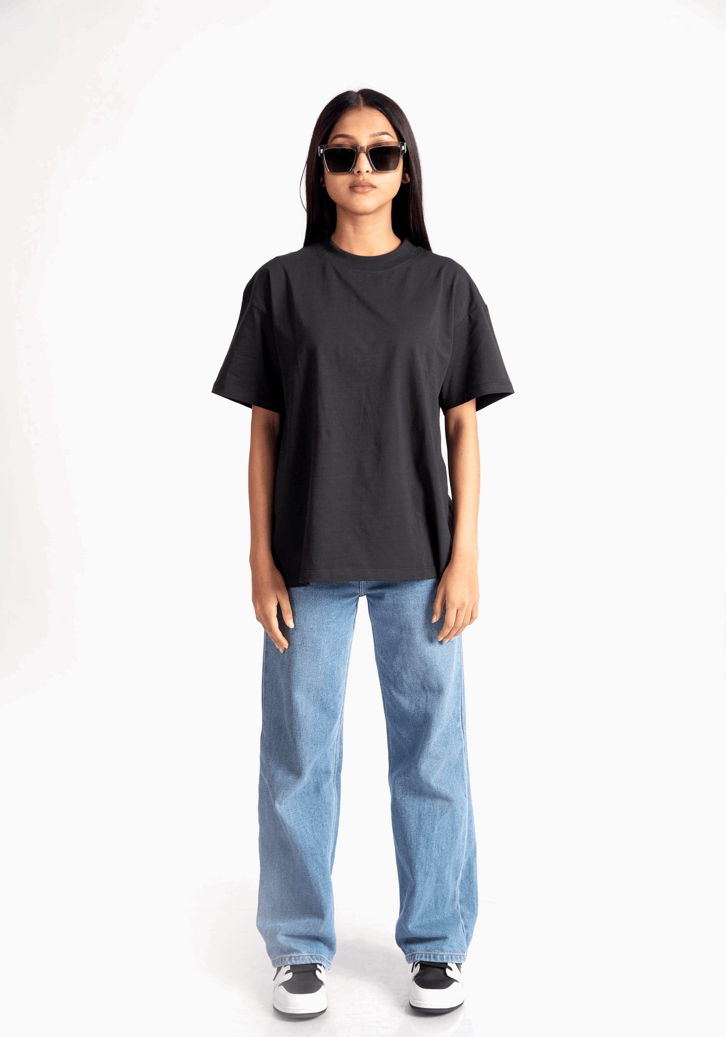 Stylera women's relaxed fit black tee worn with blue jeans and sunglasses