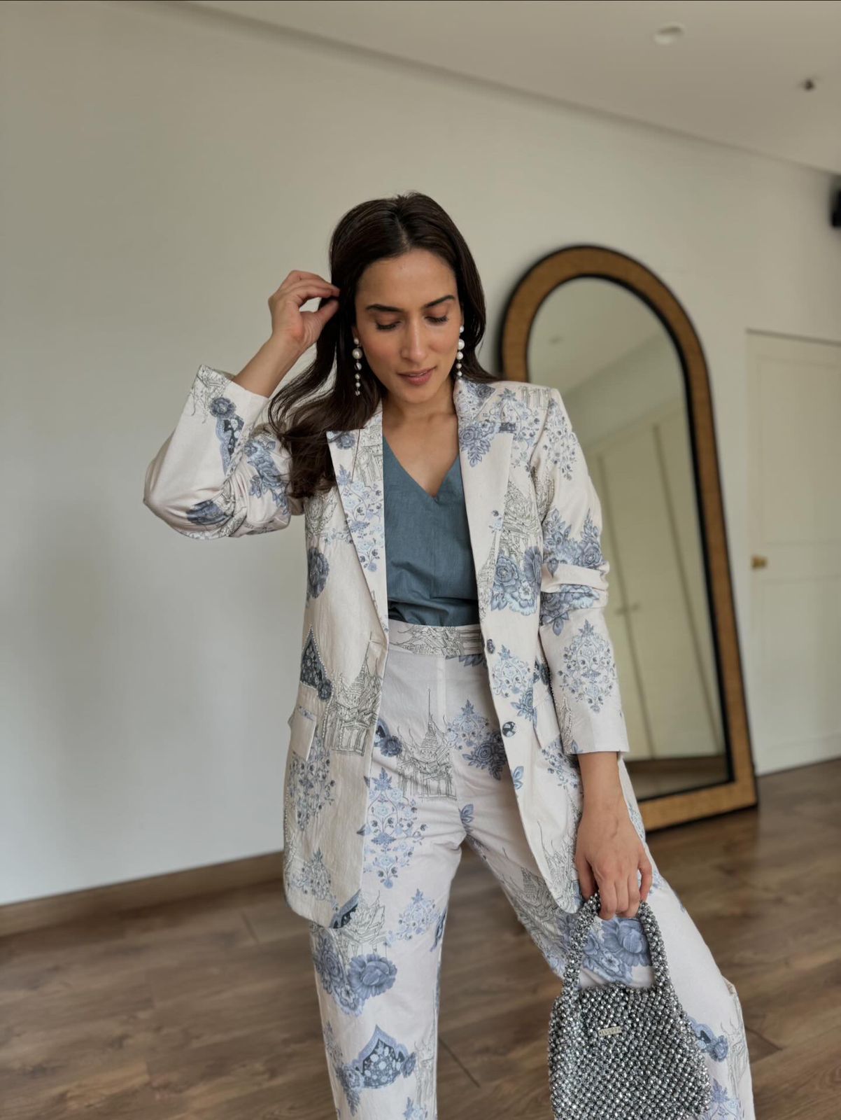 Woman modeling Stylera white and blue blazer and trousers with teal top and bag Floral print two piece set for ladies