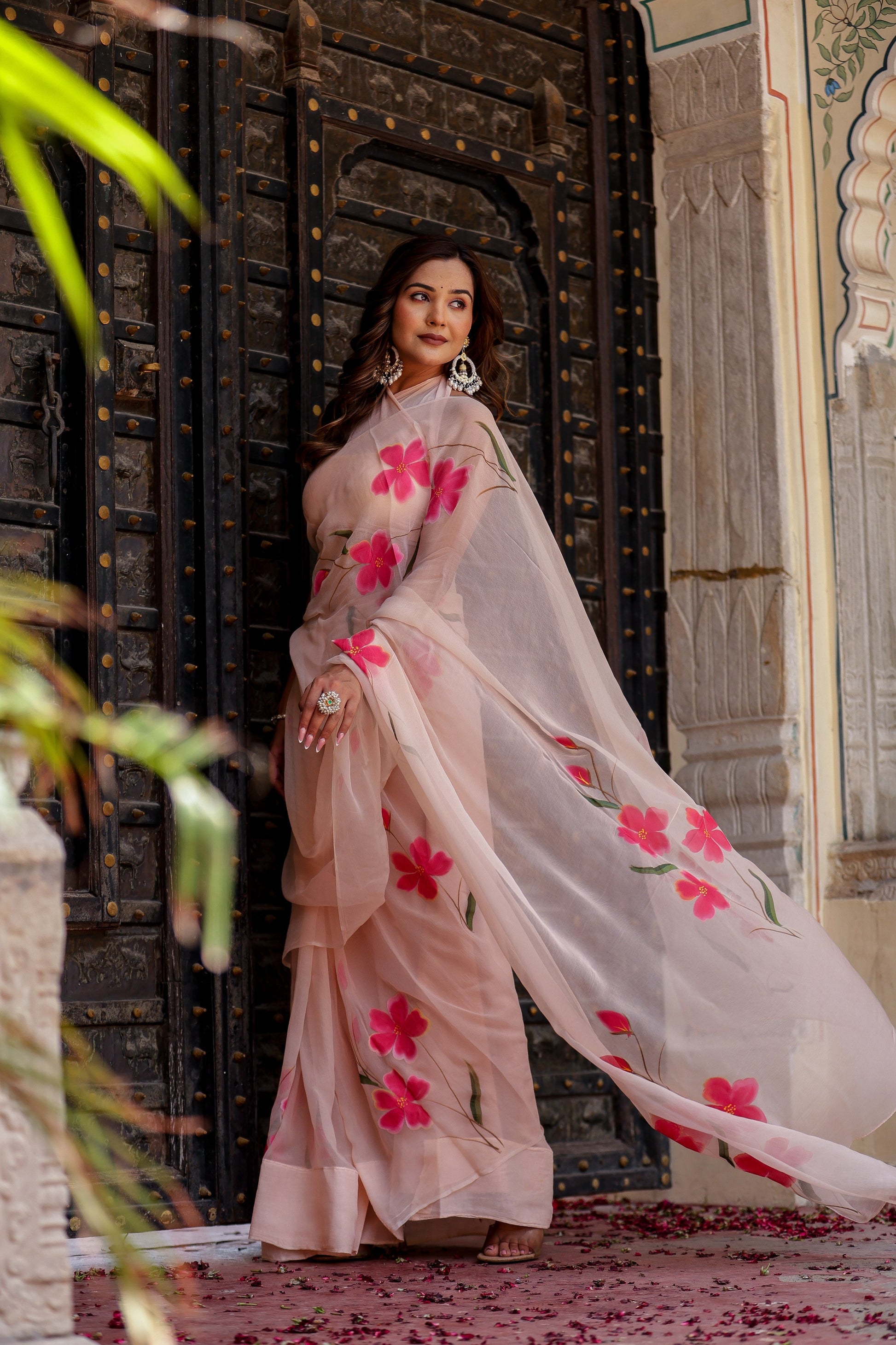 Elegant beige floral chiffon saree with pink flowers, perfect for festive occasions or weddings