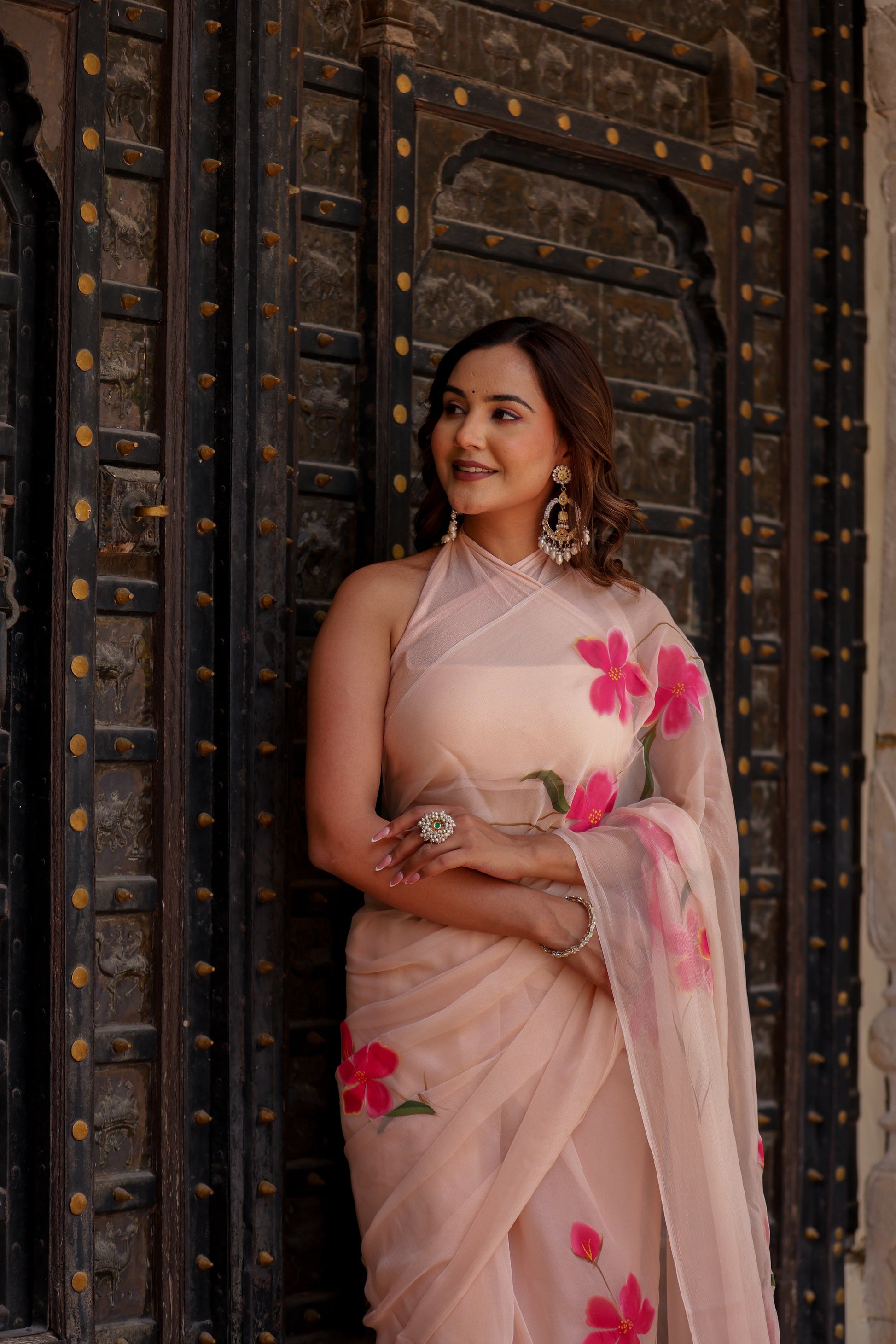Elegant beige floral chiffon saree with pink flowers, styled for a traditional look