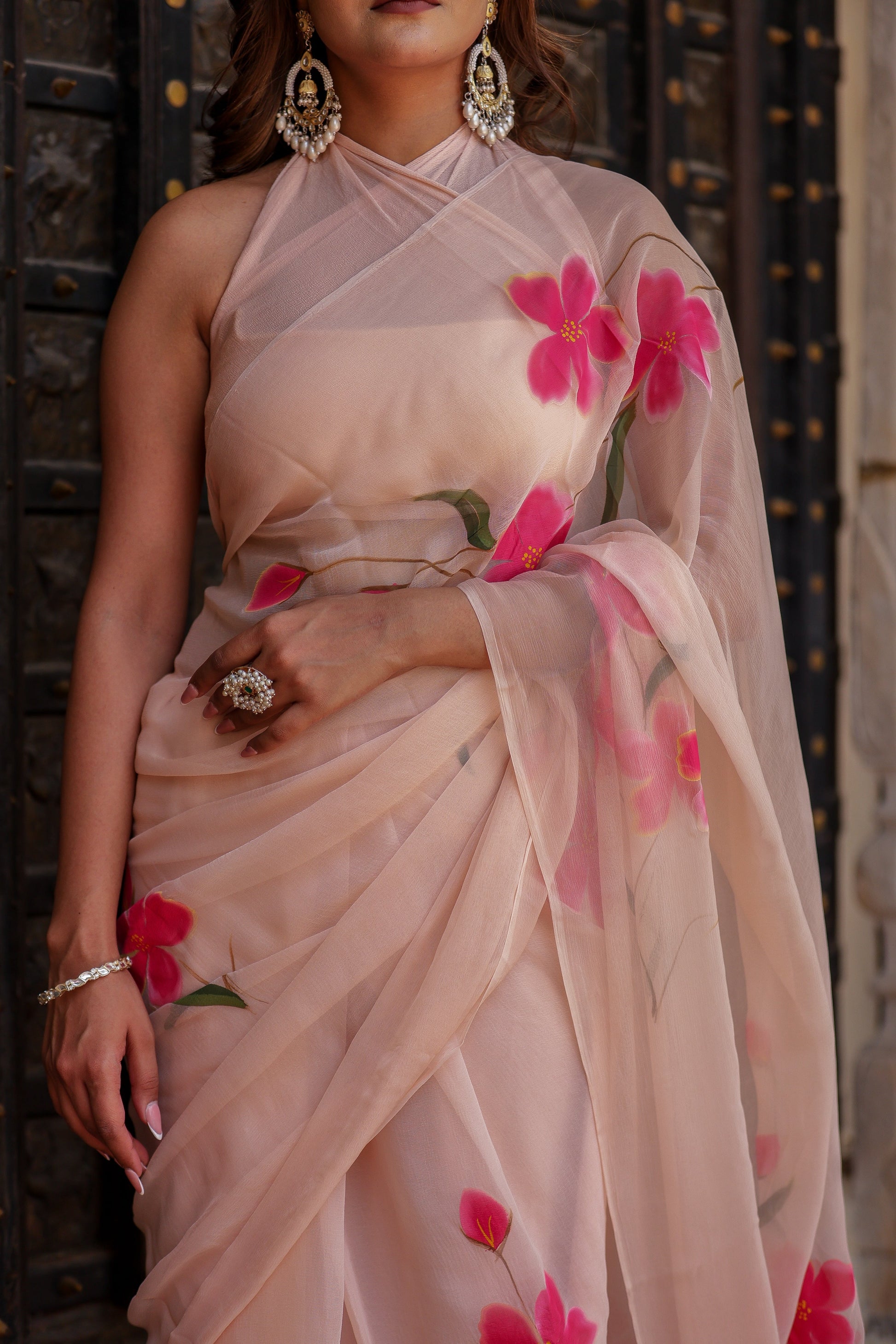 Beige floral chiffon saree with pink floral print and elegant draping for festive occasions