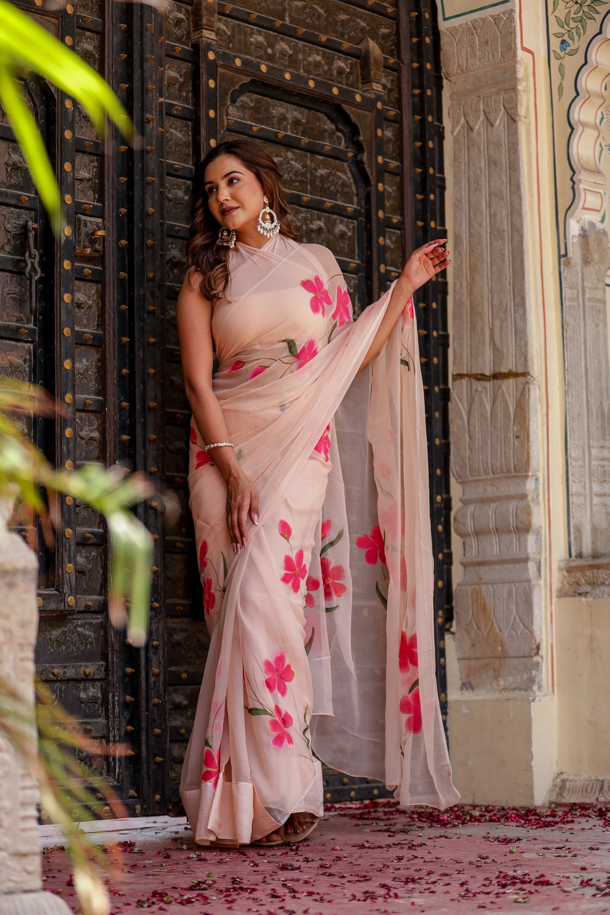 Elegant beige floral chiffon saree with vibrant pink flowers, perfect for special occasions