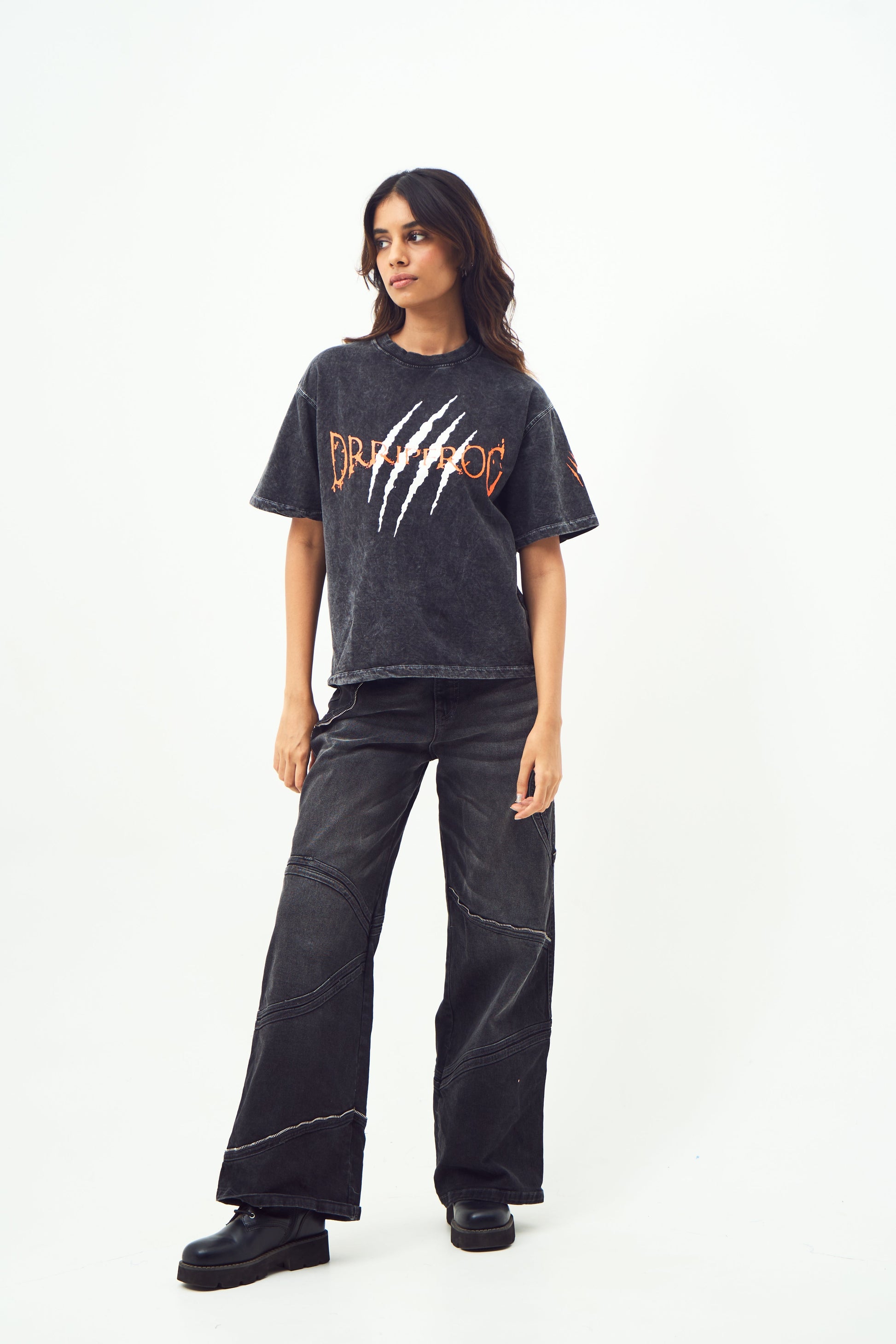 Model wearing Stylera black acid wash oversized t-shirt with claw logo paired with wide leg black jeans