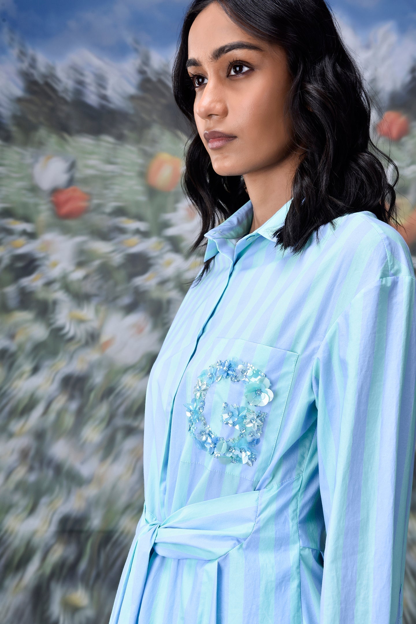 Model wearing Stylera blue green stripe dress with shirt collar cinched waist and embellished pocket