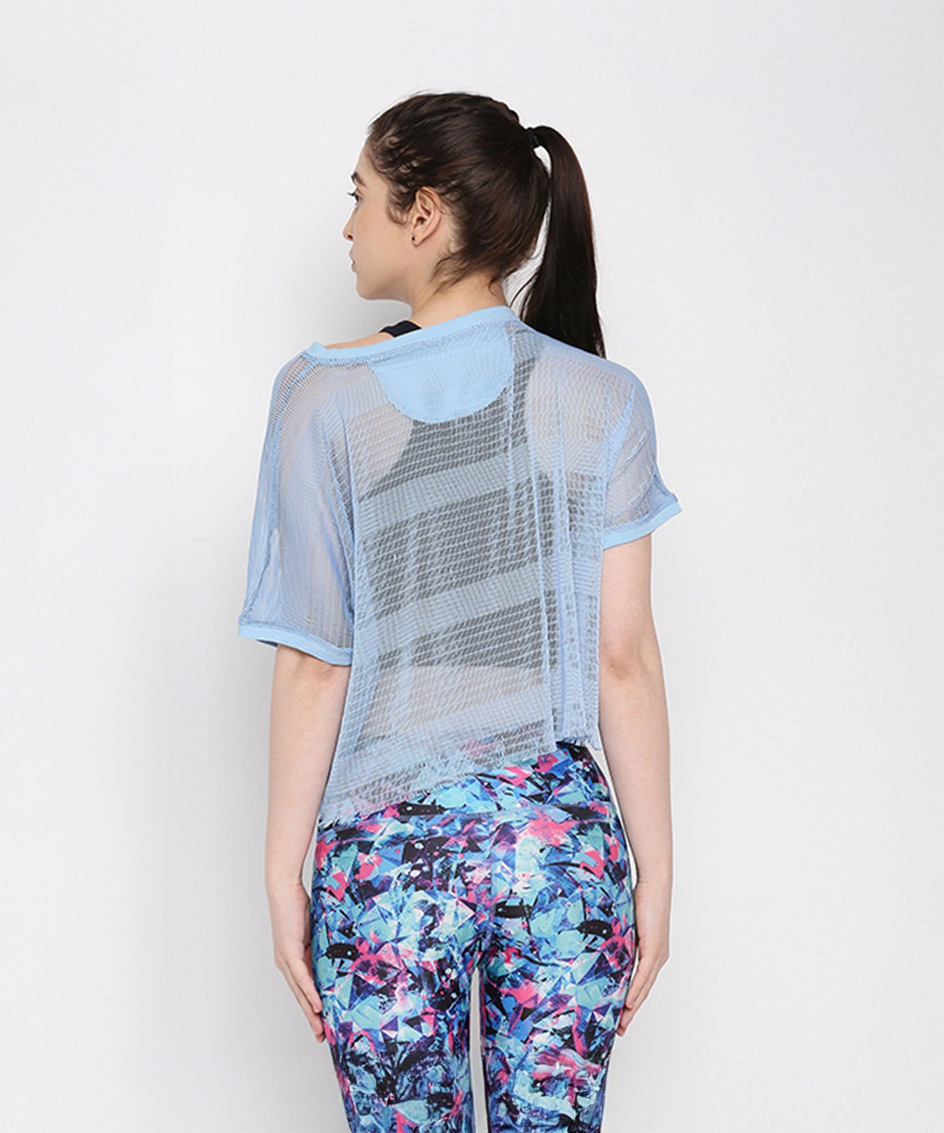 Back view of a blue netted top for women, designed for comfort and style with vibrant leggings