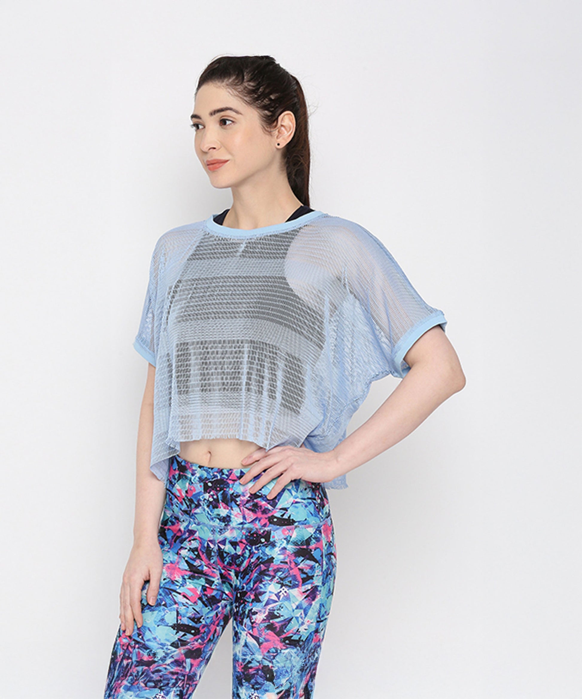Light blue netted top for women featuring a loose fit and paired with colorful leggings