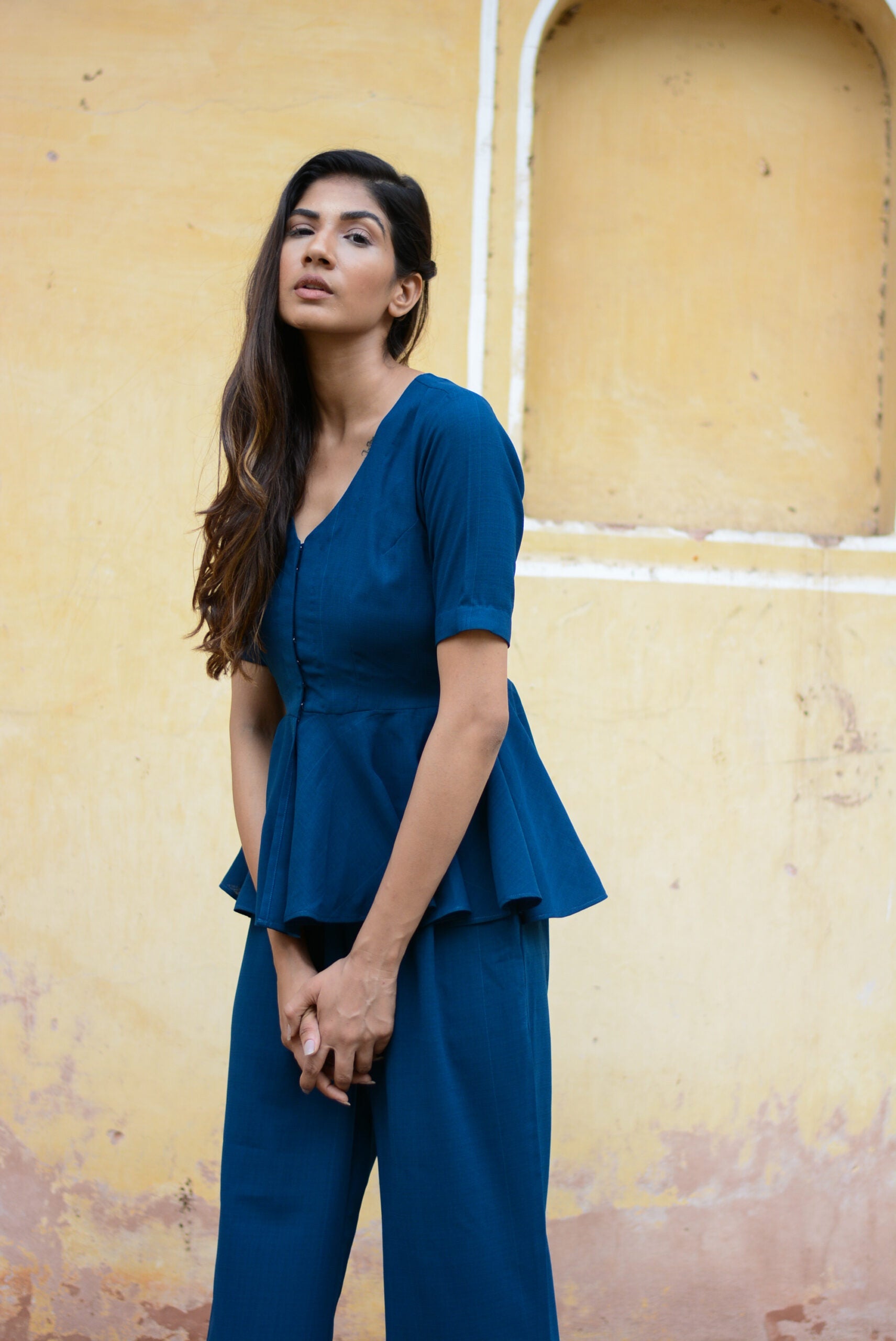Model wearing a Yale blue peplum co-ord set with a stylish peplum top and matching trousers