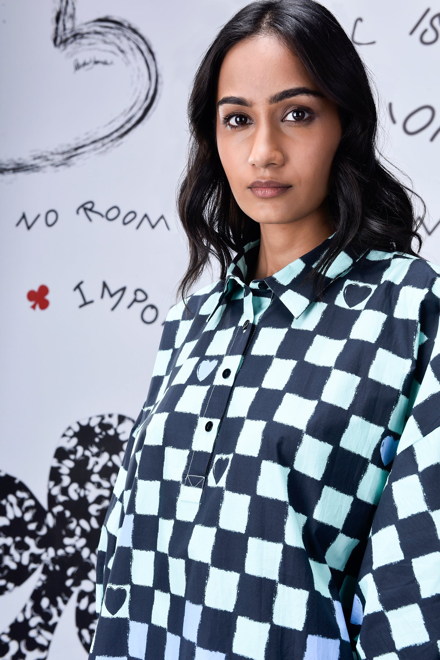Stylera model wearing a blue and black chess board print oversized shirt with button front collar