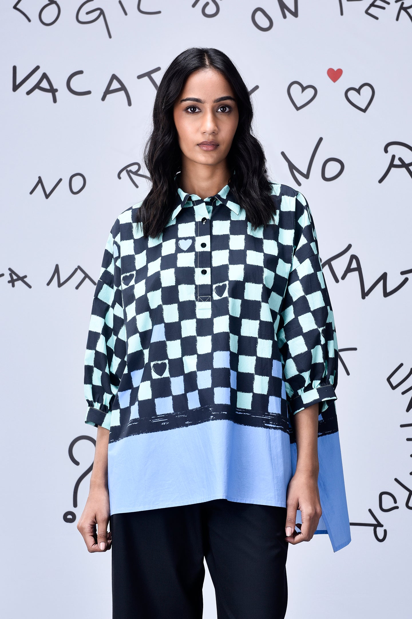 Stylera model wearing a blue and black chess board print oversized shirt with contrast hem
