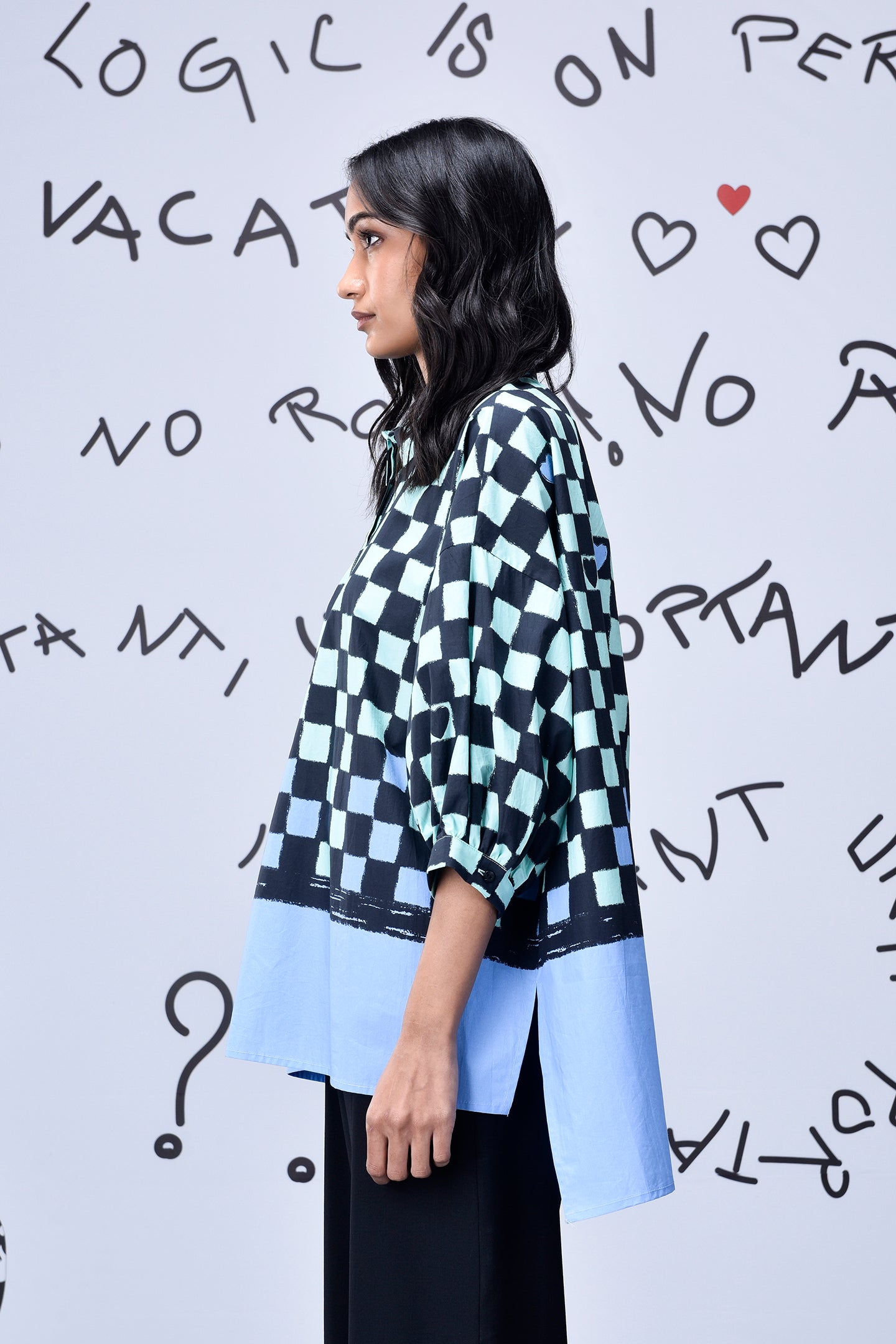 Woman side profile wearing Stylera chess board print oversized shirt with blue hem
