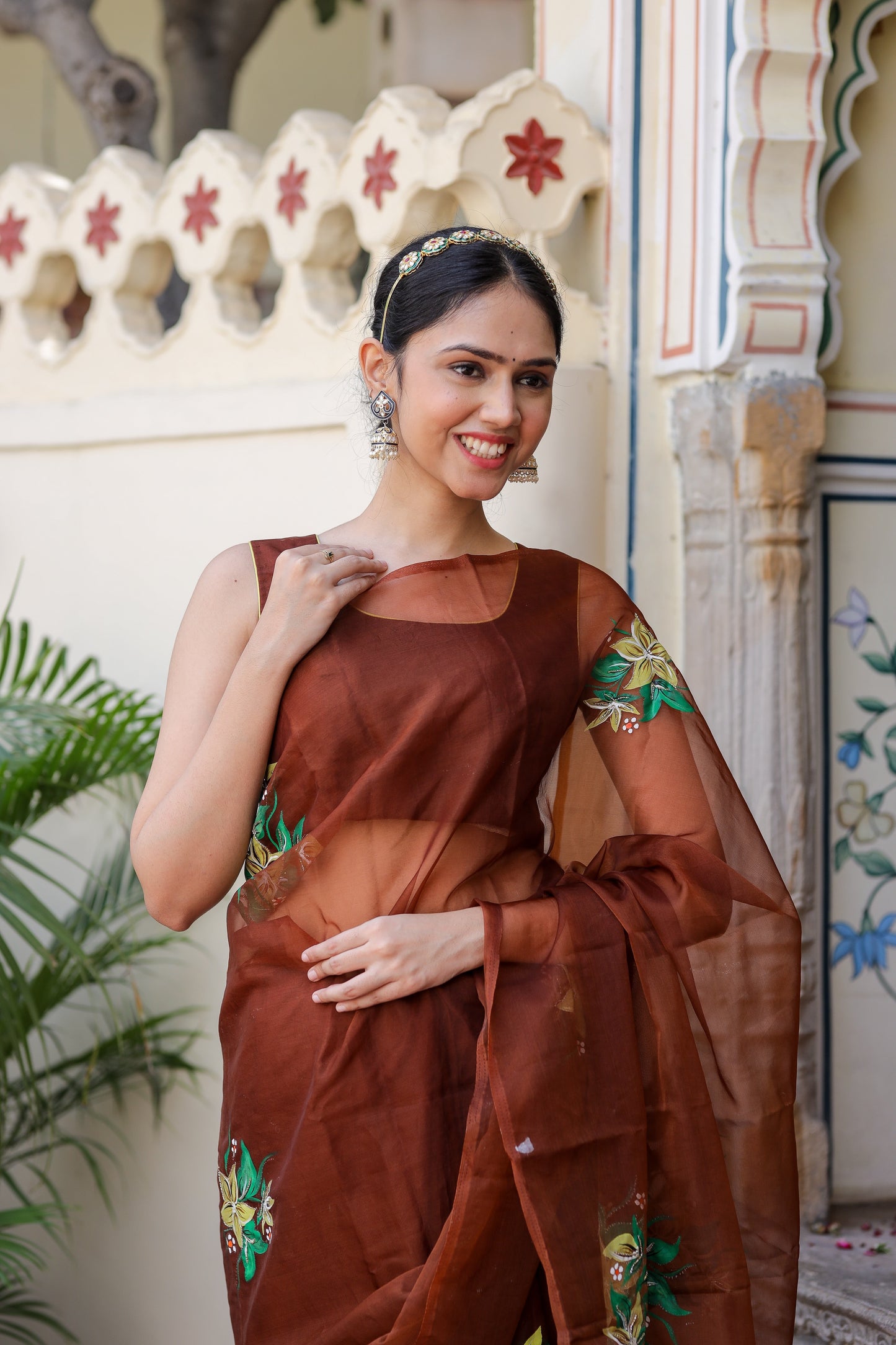 Elegant woman wearing a designer brown saree for wedding with intricate embroidery details