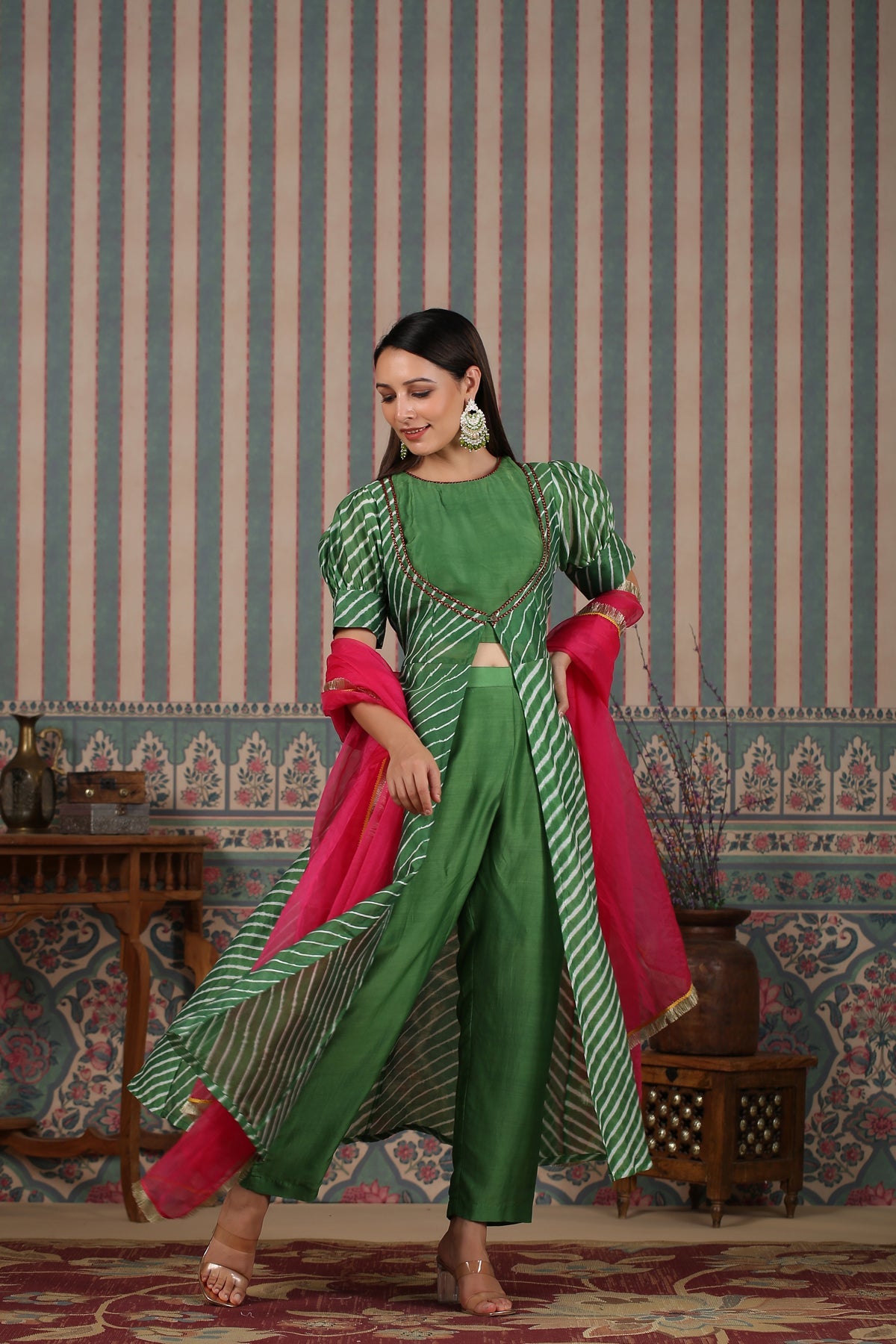 Elegant green designer lehriya dress for women with contrasting pink dupatta and stylish detailing