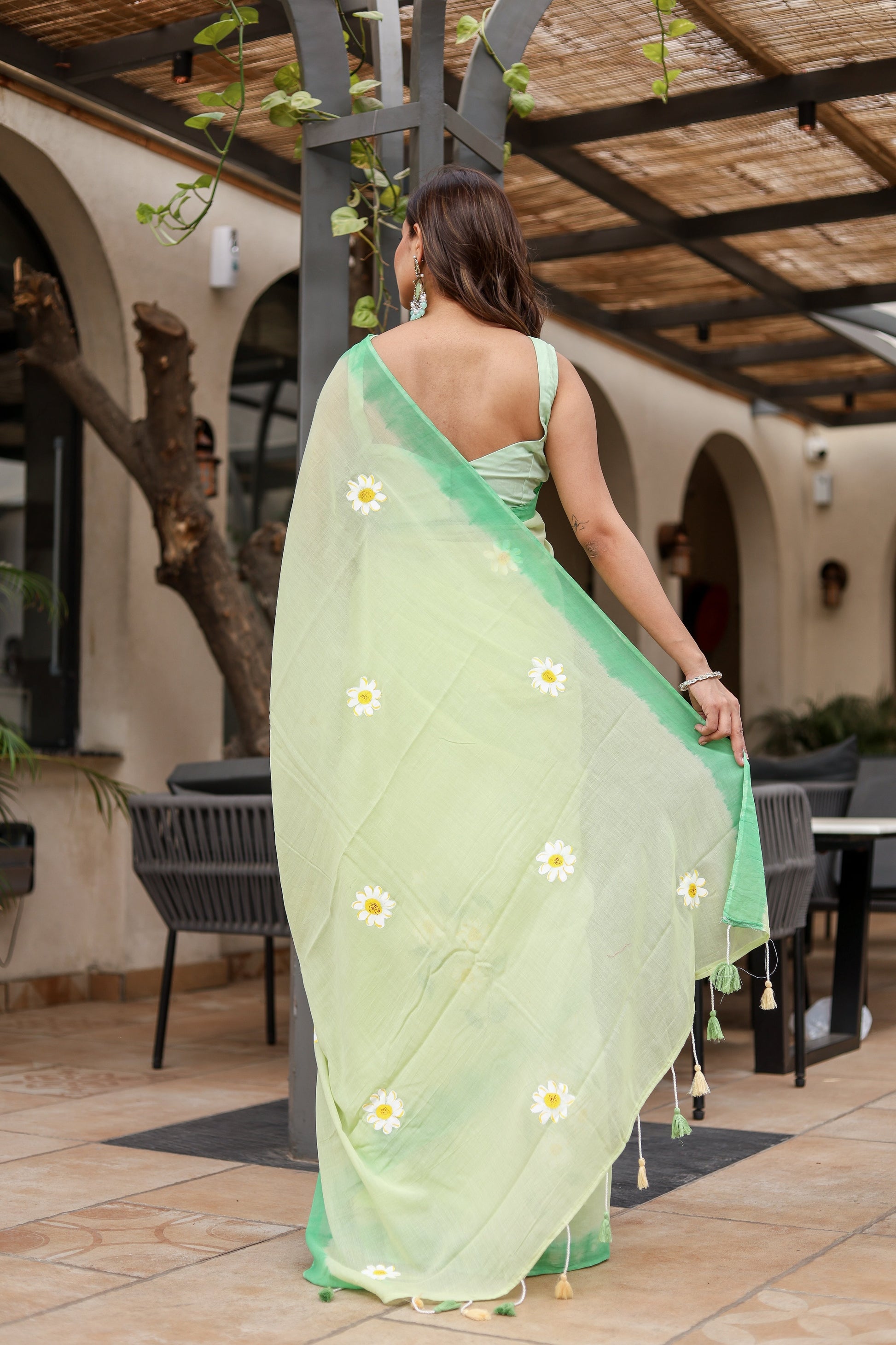 Stylish designer malmal saree with flowers in light green, elegantly draped for a chic look
