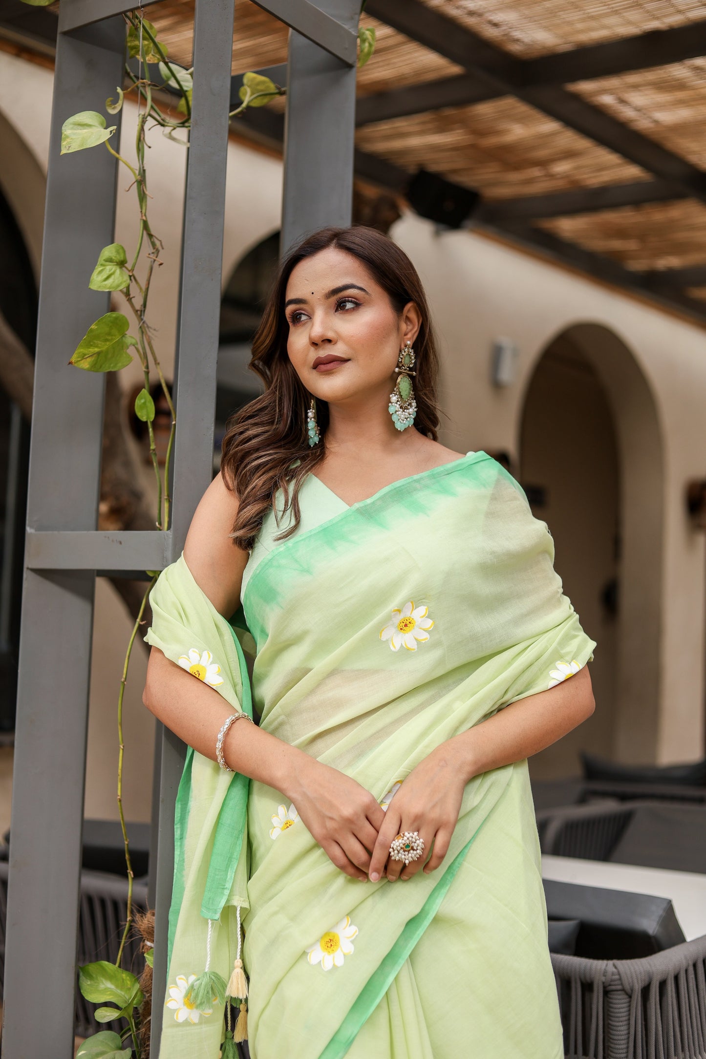 Stylera designer malmal saree with flowers in light green, elegantly draped on a model outdoors