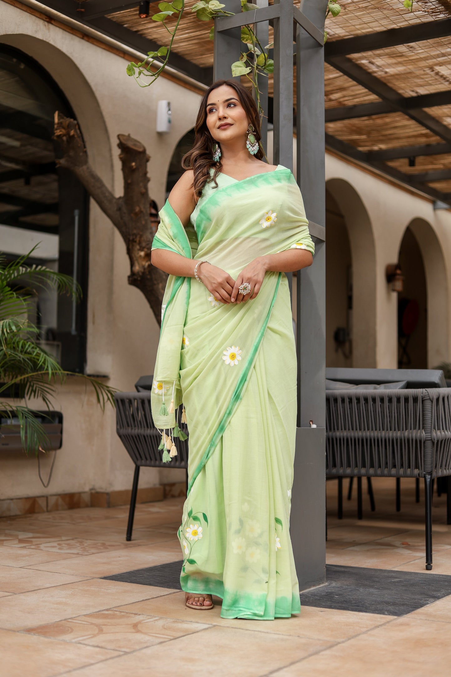 Elegant designer malmal saree with flowers in light green, perfect for festive occasions
