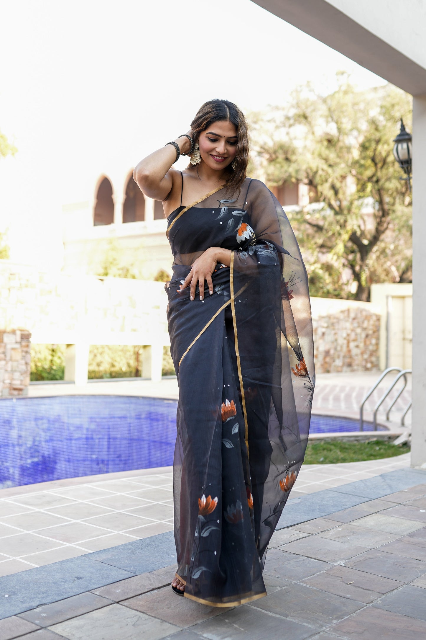 Elegant designer party wear saree for women in black with floral patterns and a stylish drape