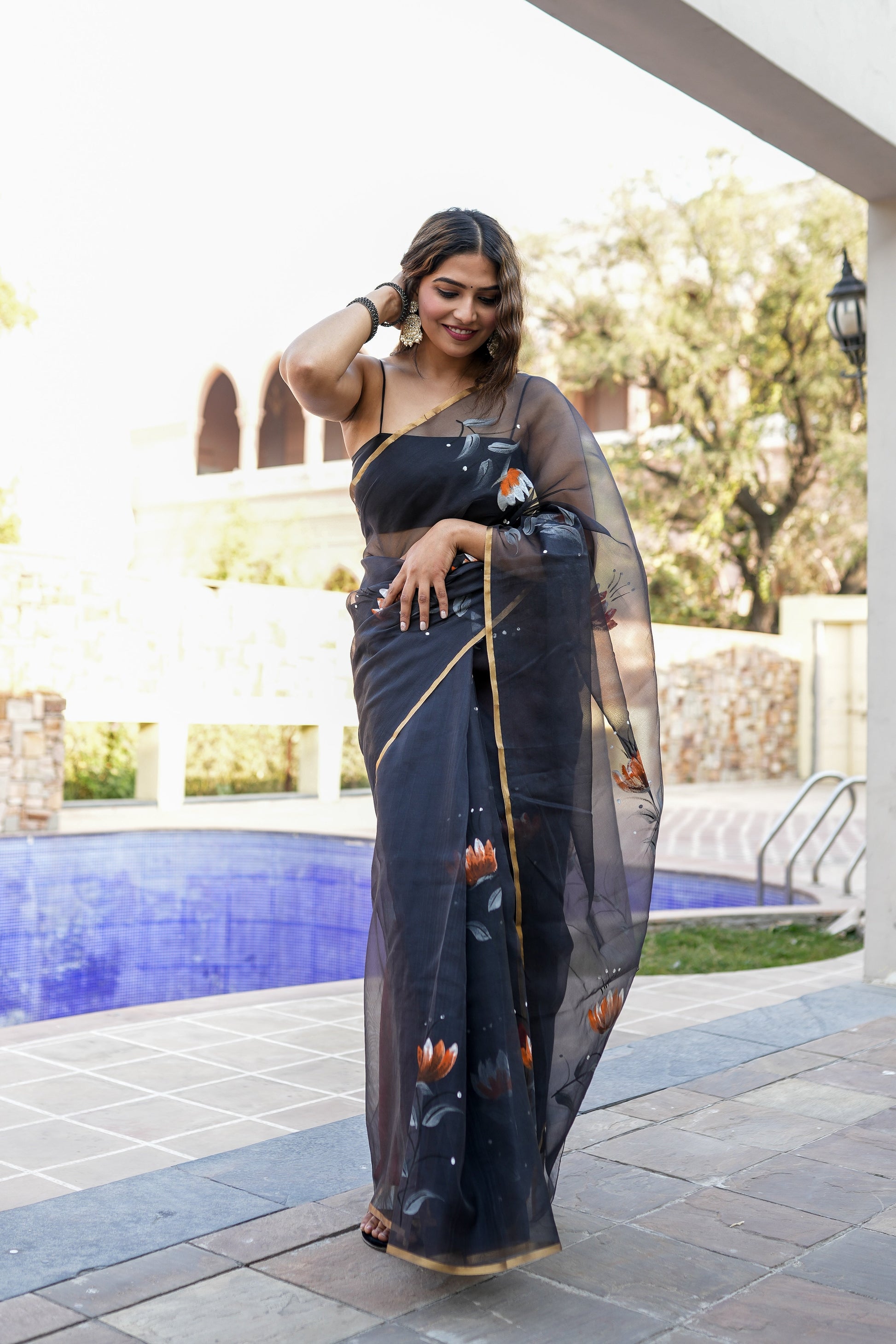 Elegant designer party wear saree for women in black with floral patterns and a stylish drape