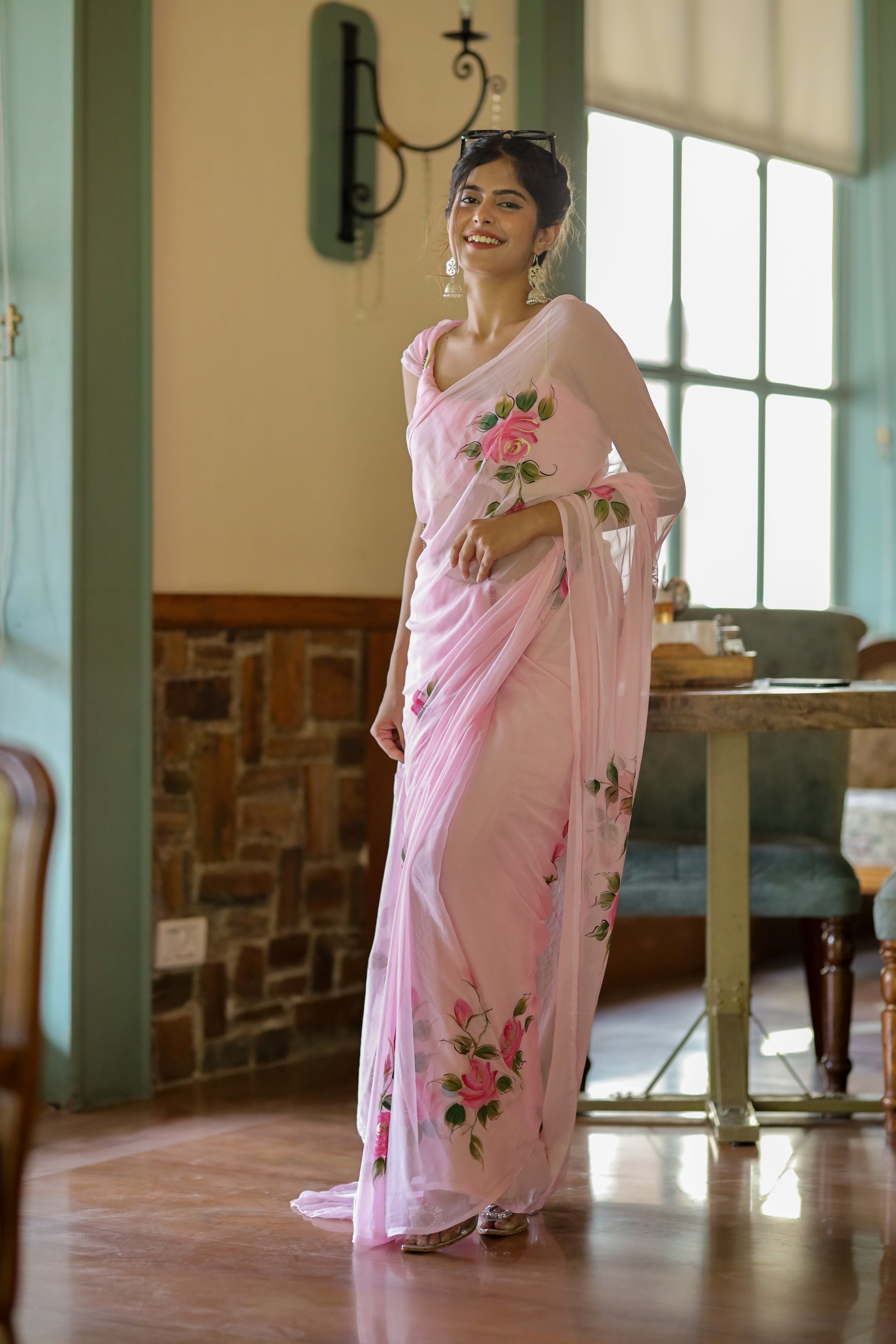 Model wearing an elegant party wear chiffon saree in light pink with floral embroidery accents