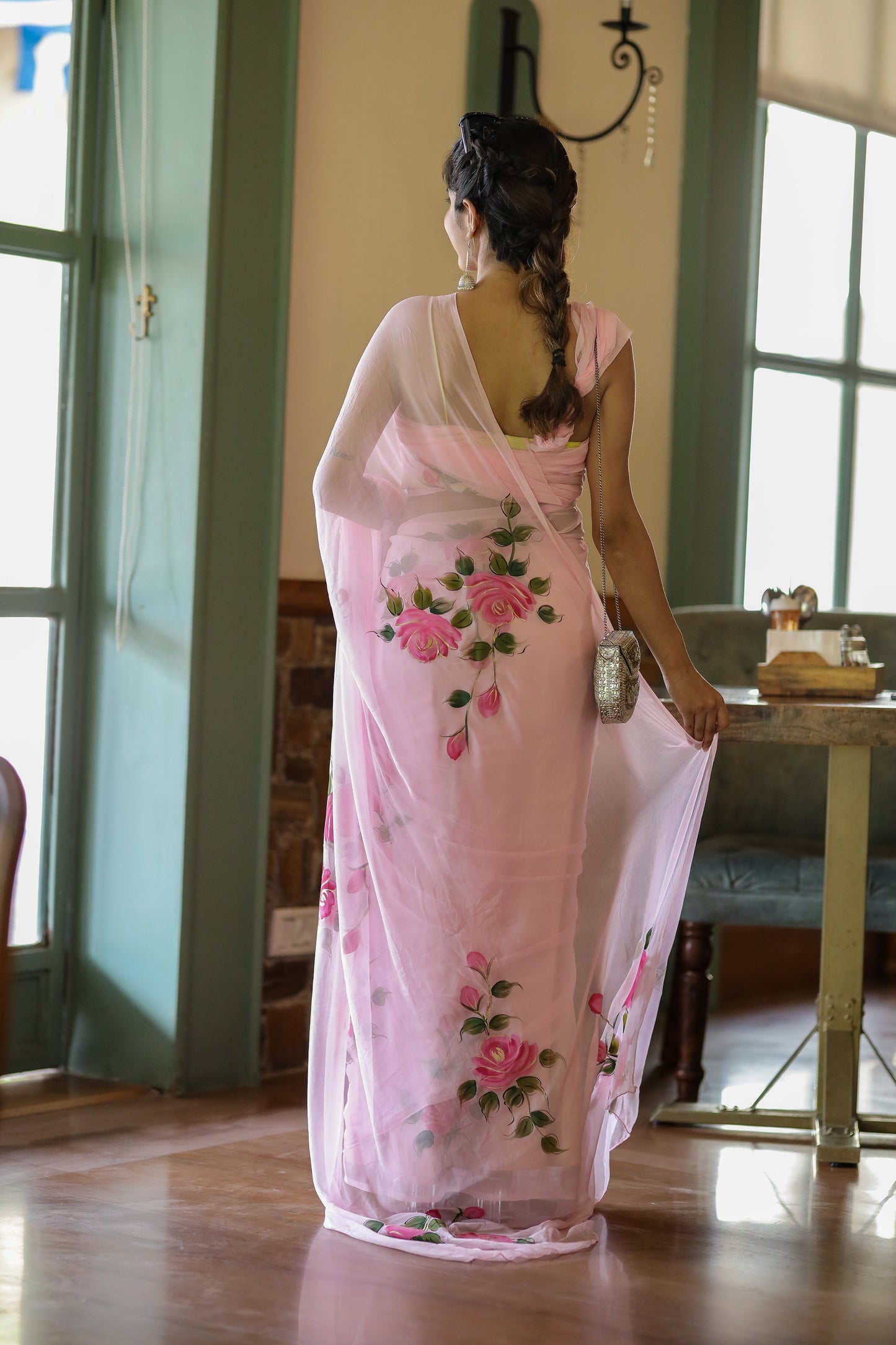 Woman wearing an elegant party wear chiffon saree with floral embroidery in a bright indoor setting