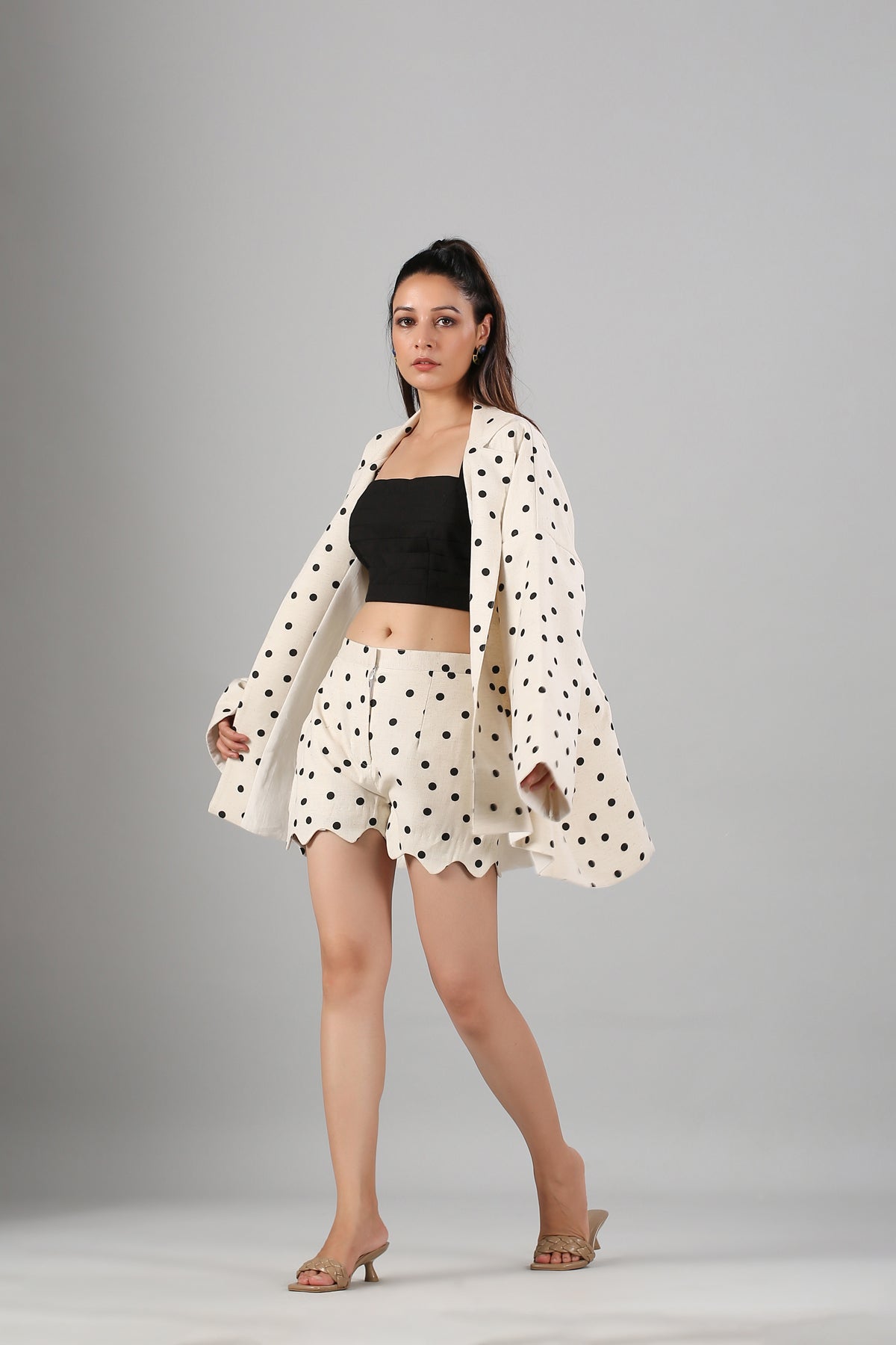 Model wearing Stylera polka dot cream blazer and scalloped shorts with black bandeau top fashionable two piece suit for ladies