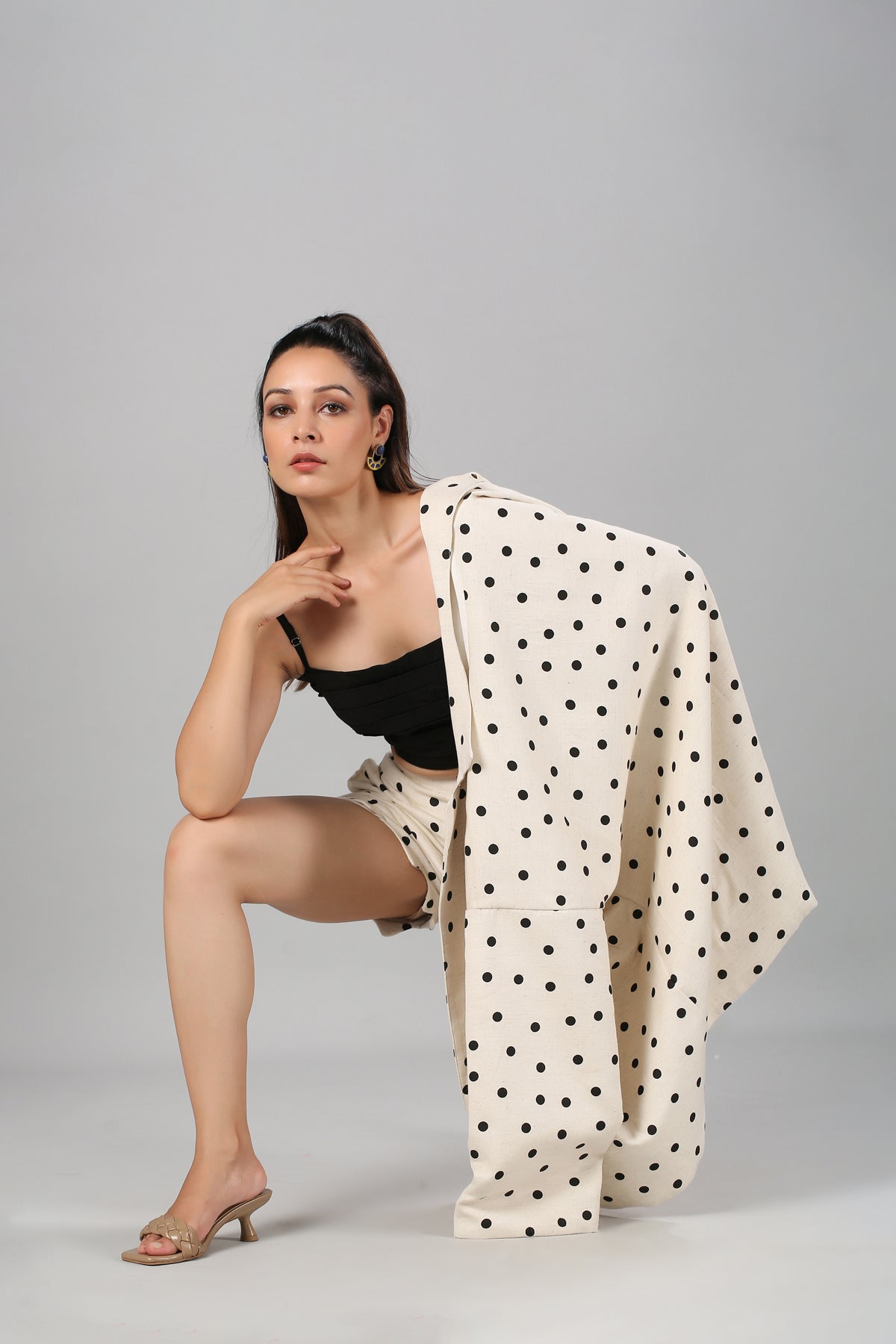 Model wearing Stylera fashionable two piece suit for ladies cream polka dot blazer and shorts with black tube top