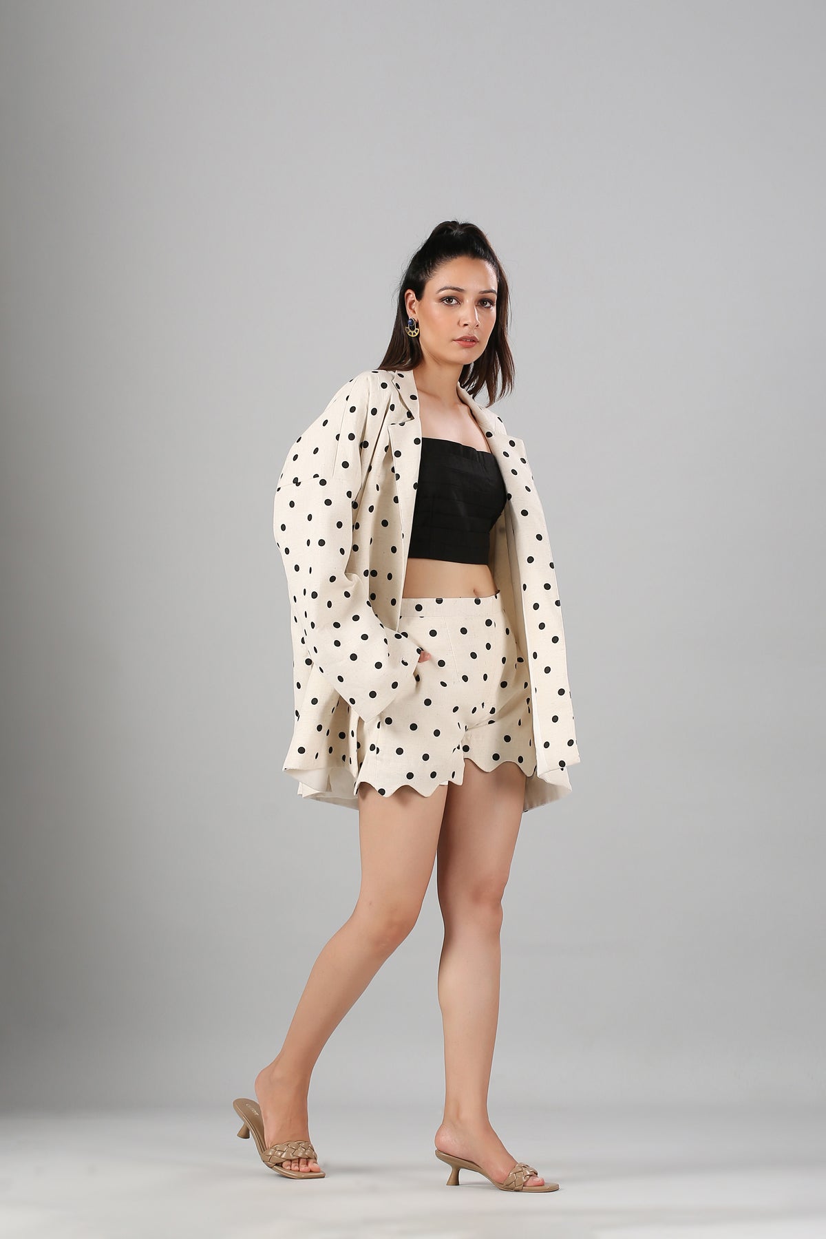 Model wearing Stylera polka dot blazer and scalloped shorts with black crop top fashionable two piece suit for ladies
