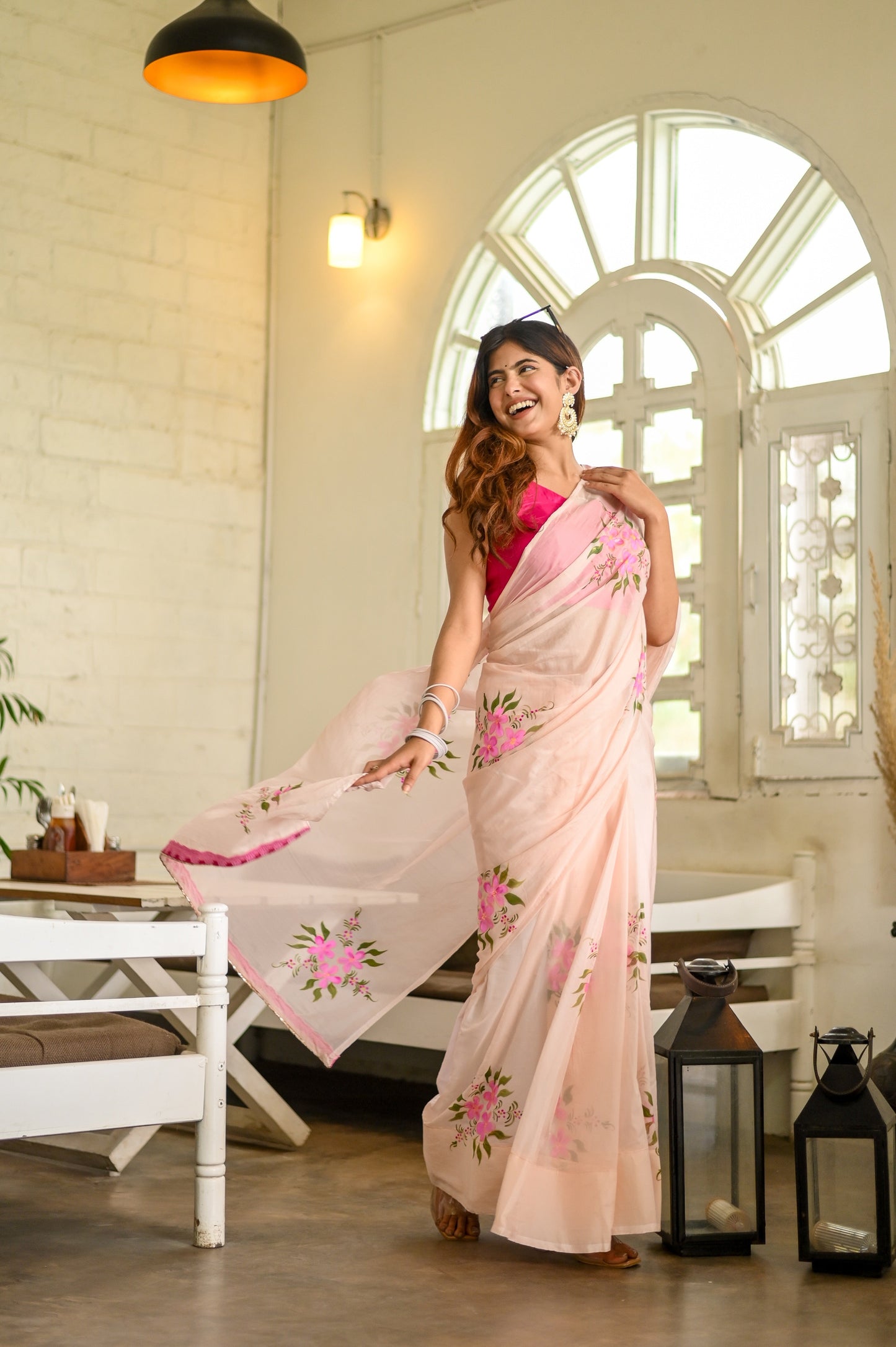 Elegant floral organza saree for women in light pink with vibrant floral designs and a graceful drape