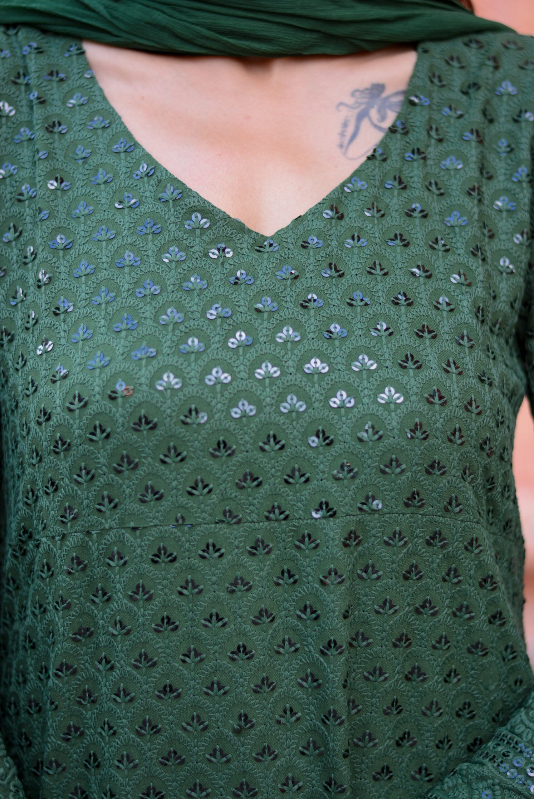 Close-up of green three piece suit for women with intricate floral cutwork design