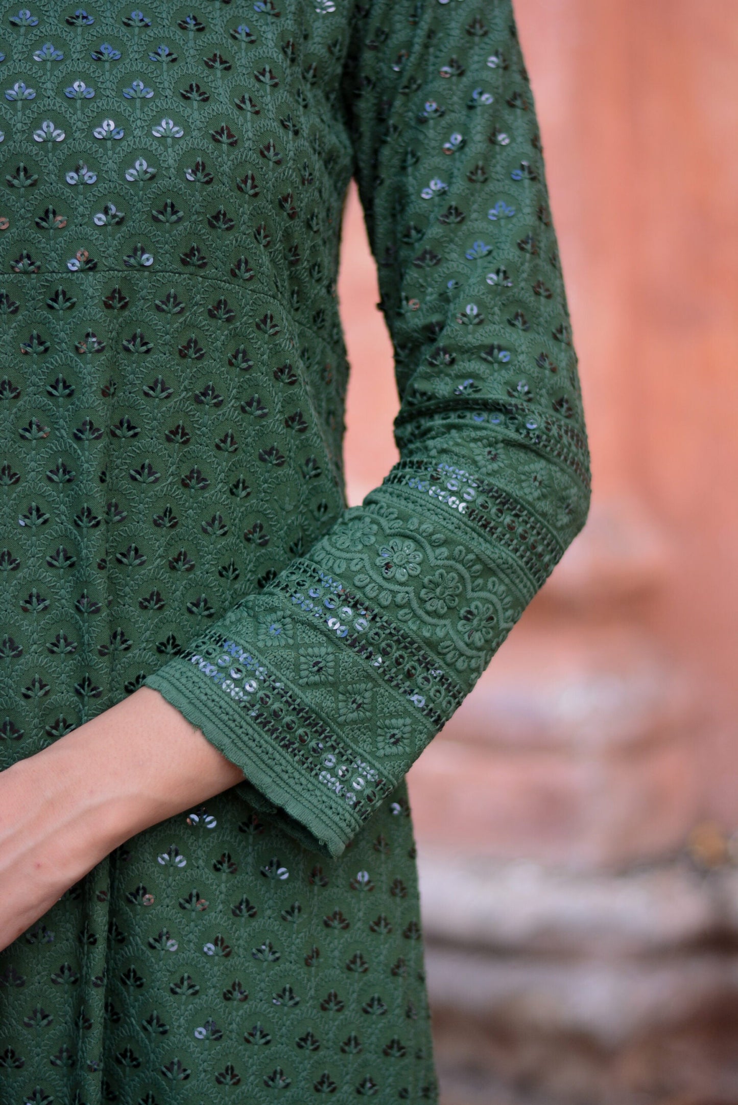 Close-up of sleeve detail on a green three piece suit for women with intricate embroidery and sequin work