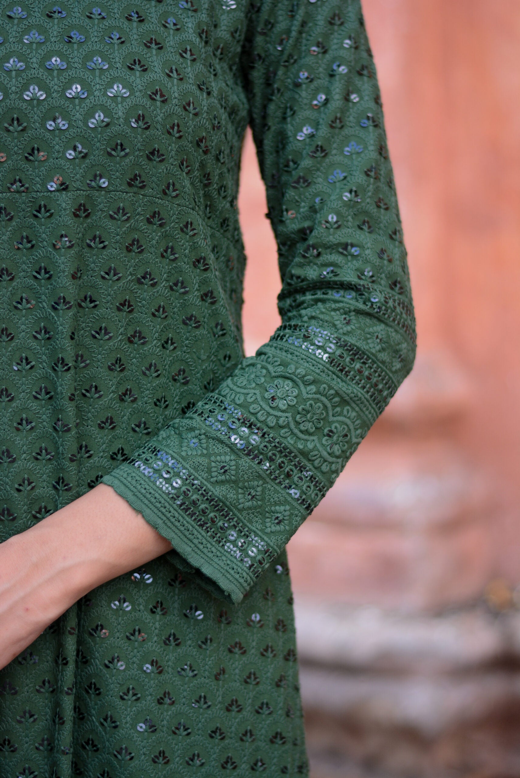 Close-up of sleeve detail on a green three piece suit for women with intricate embroidery and sequin work