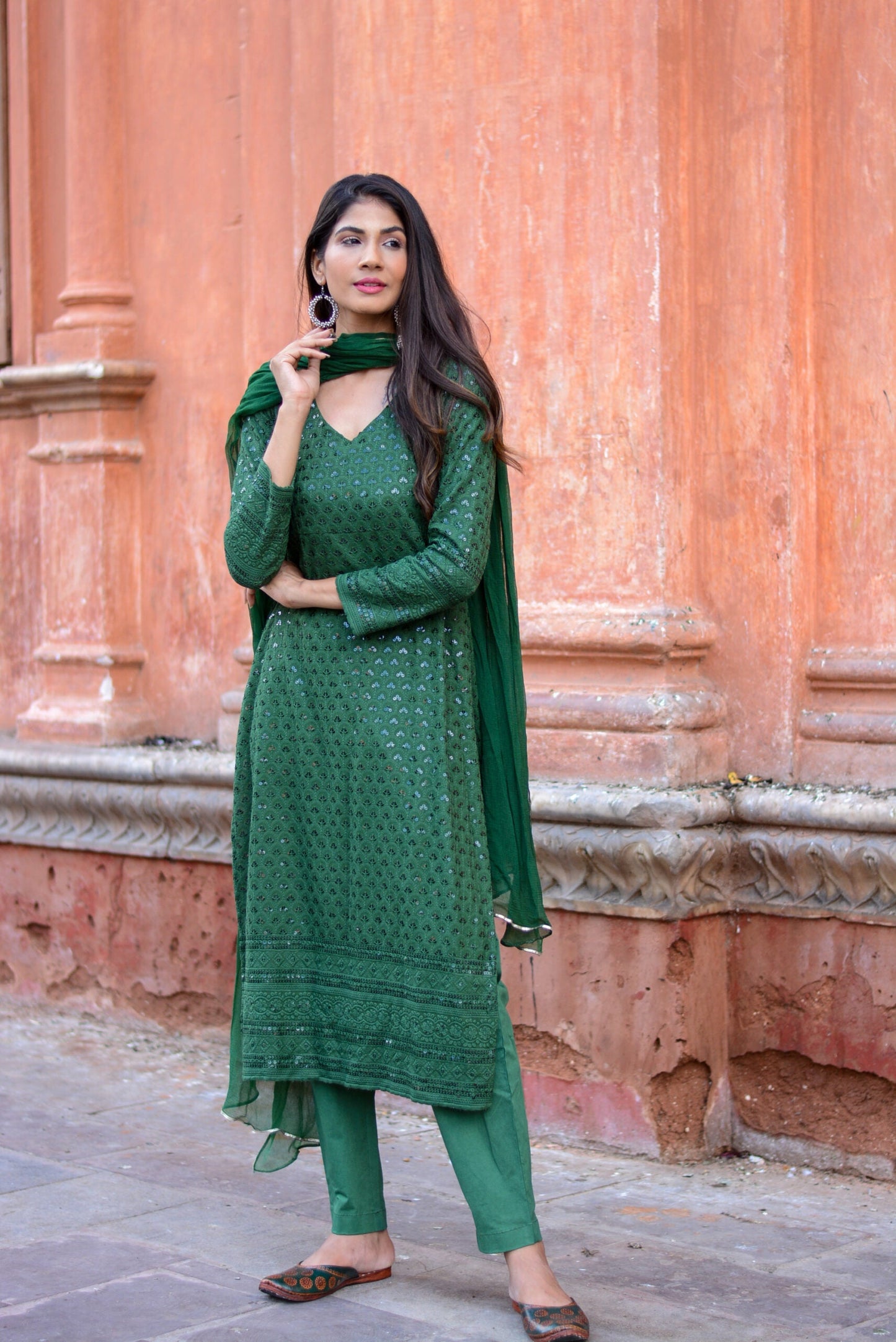 Woman wearing green three piece suit for women with scarf and detailed embroidery outdoors