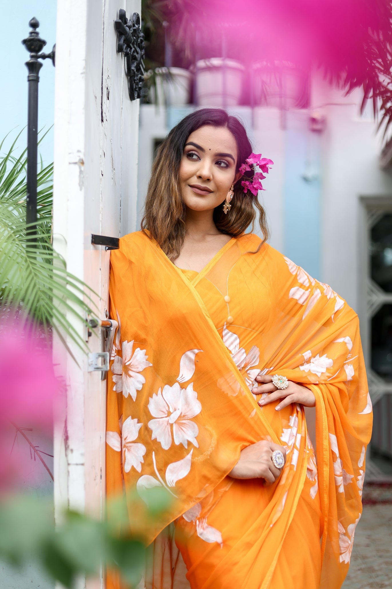 Stylera handpainted chiffon saree in vibrant orange with floral patterns for elegant occasions