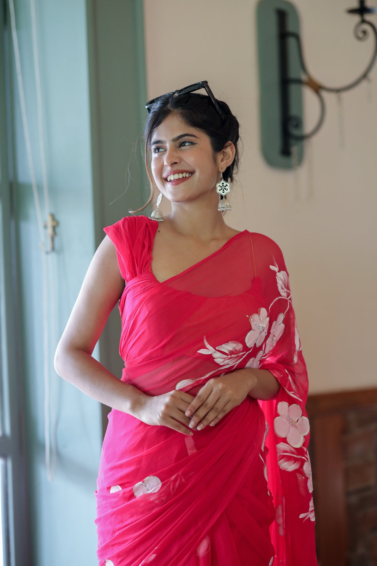 Elegant handpainted chiffon saree rani pink draped on a model, showcasing floral designs and a stylish look