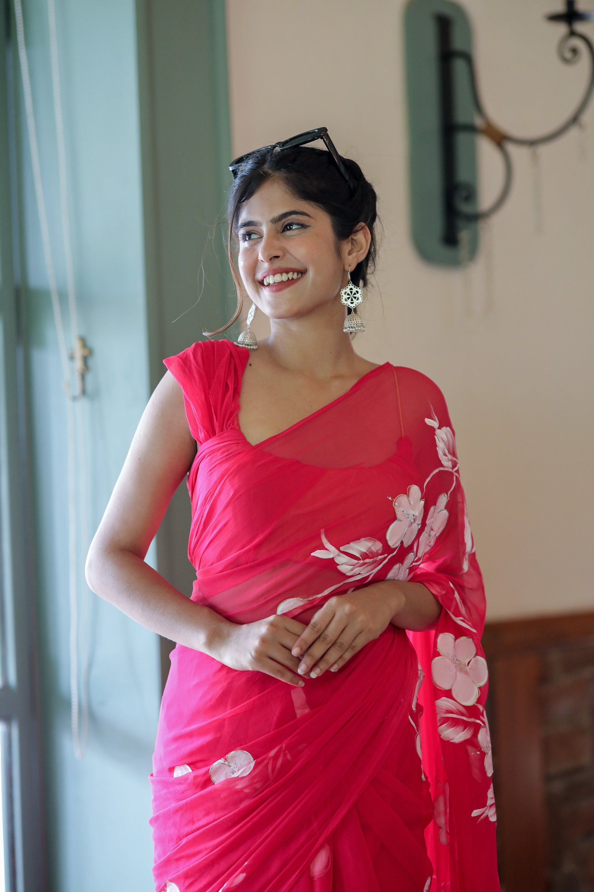 Elegant handpainted chiffon saree rani pink draped on a model, showcasing floral designs and a stylish look
