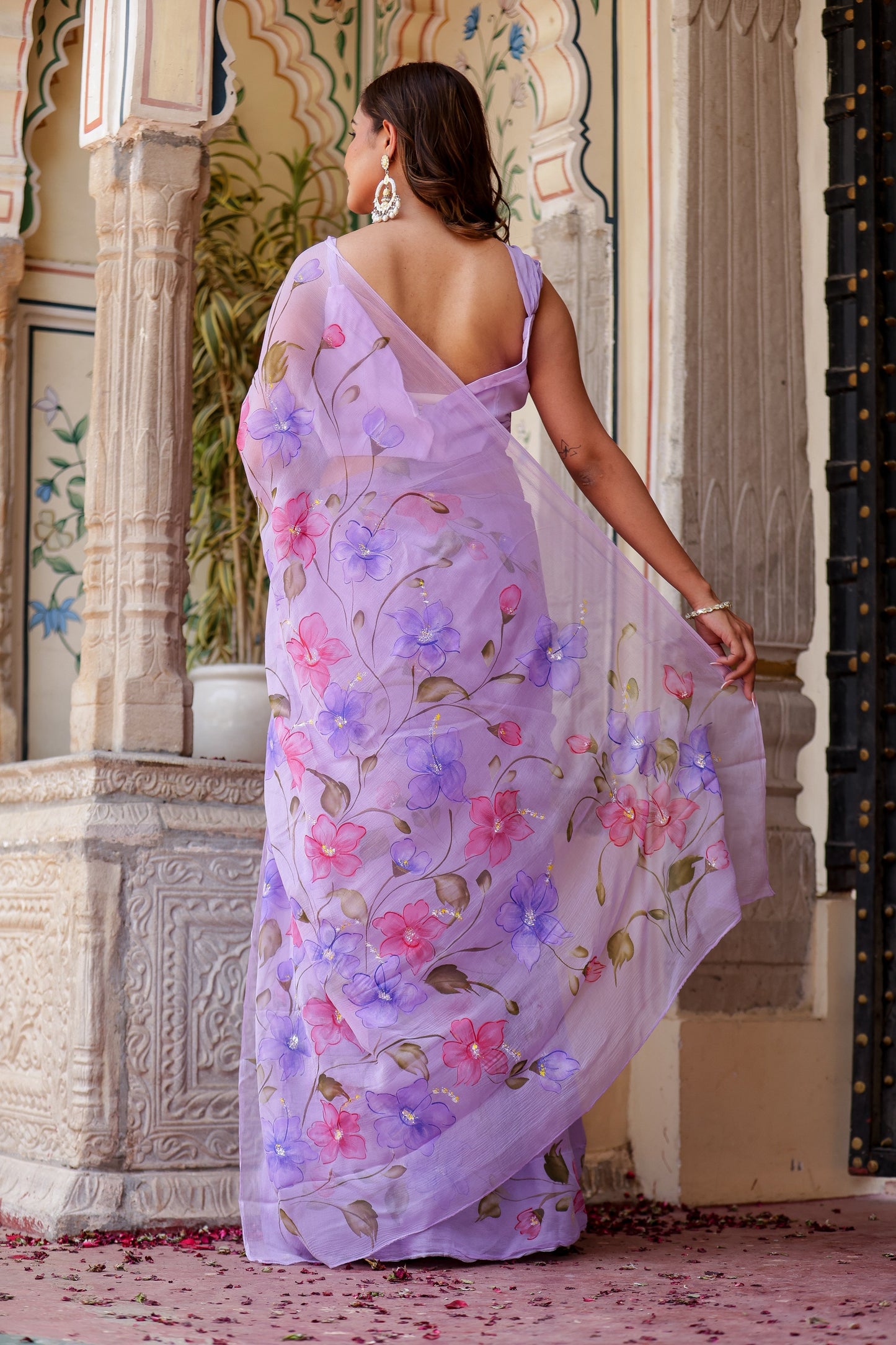 Elegant handpainted lavender chiffon saree adorned with floral designs, perfect for special occasions