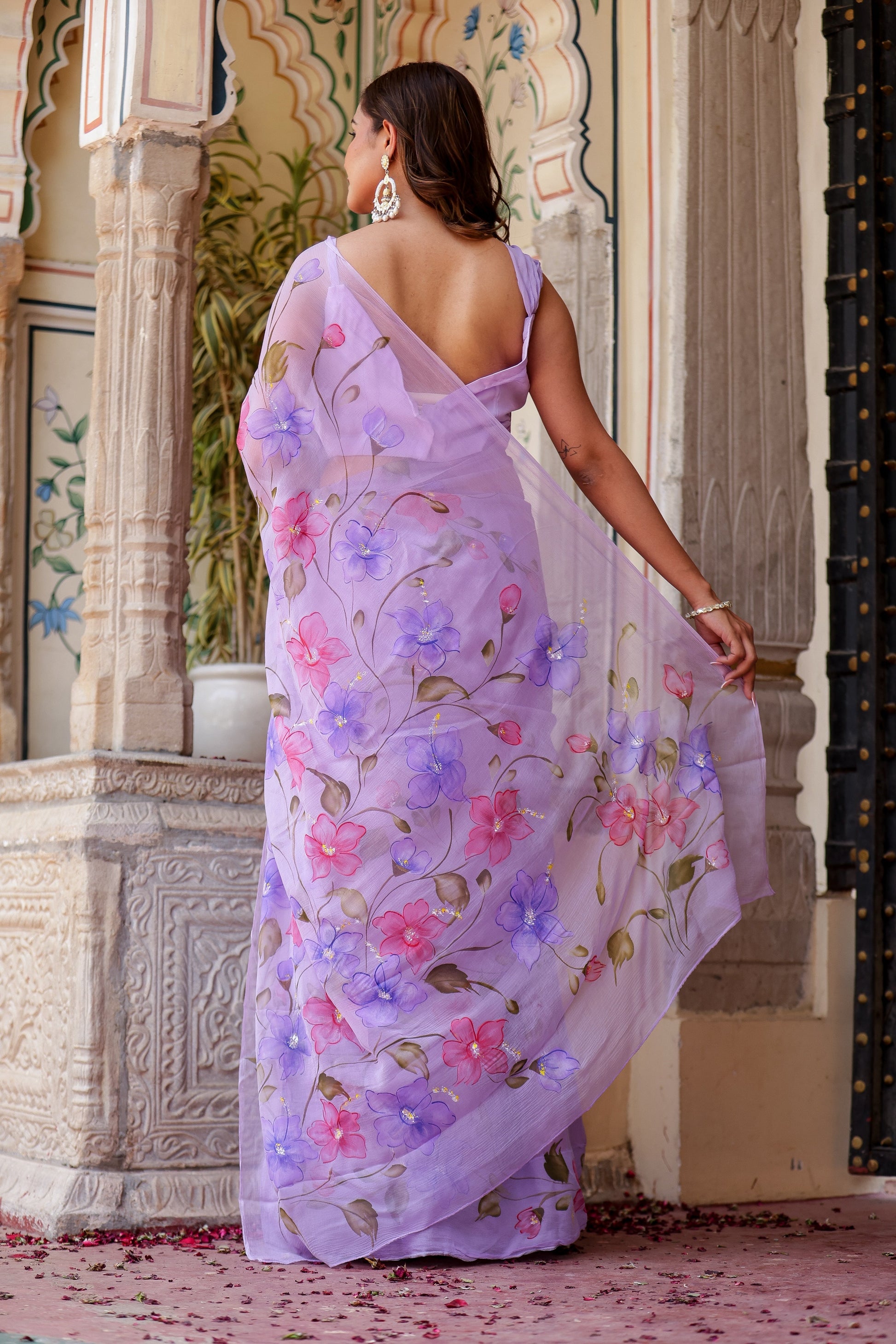Elegant handpainted lavender chiffon saree adorned with floral designs, perfect for special occasions