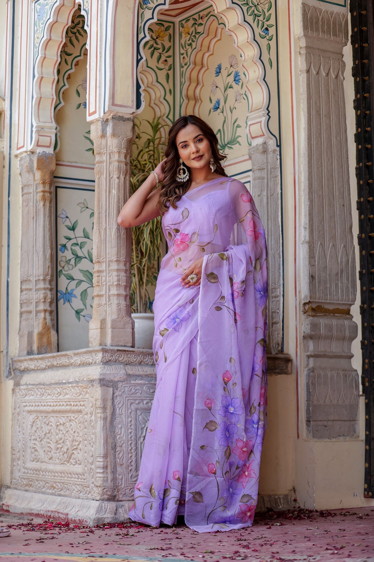 Elegant handpainted lavender chiffon saree adorned with floral designs, perfect for festive occasions
