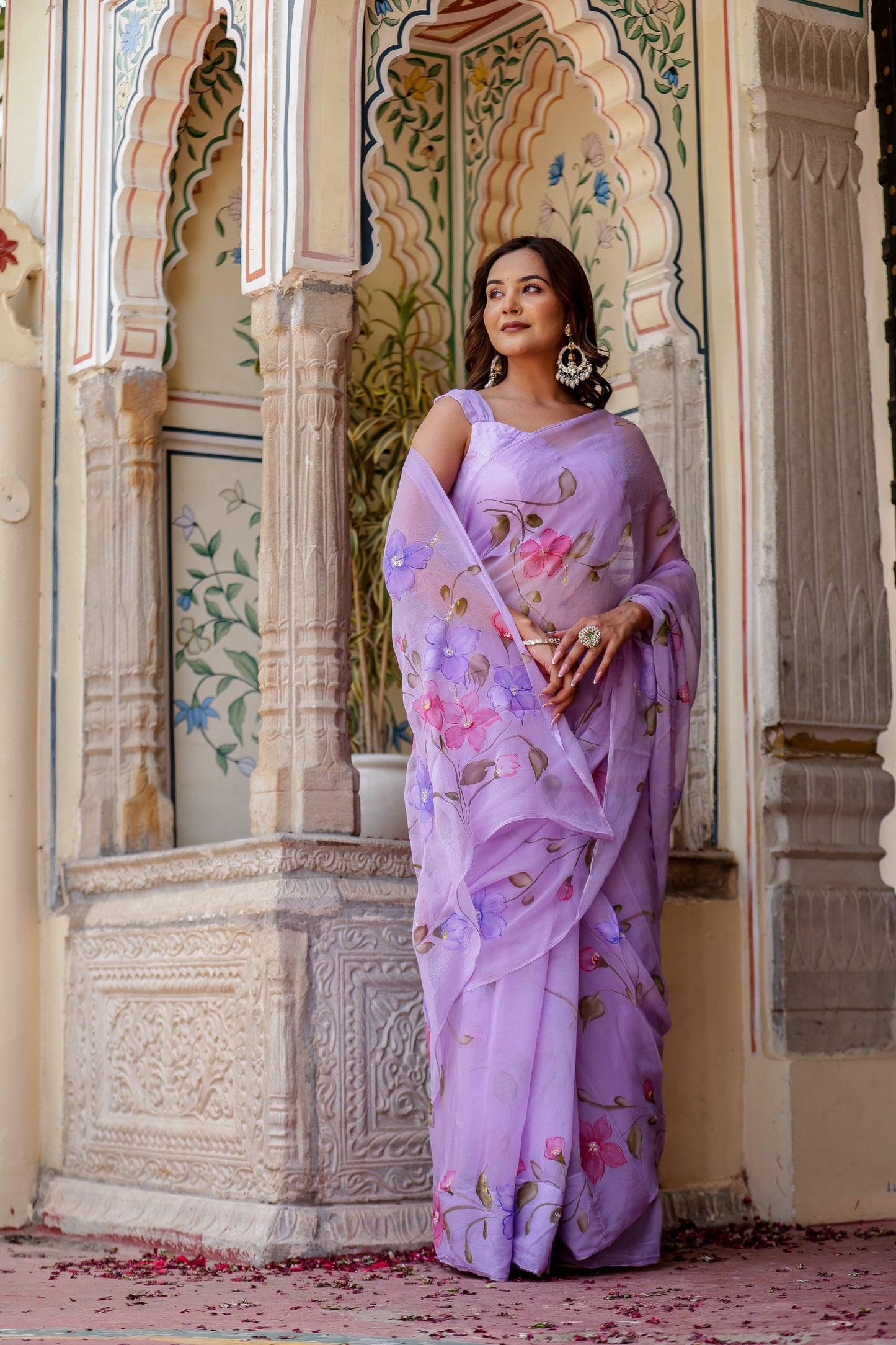 Elegant model wearing a handpainted lavender chiffon saree with floral designs, showcasing traditional style