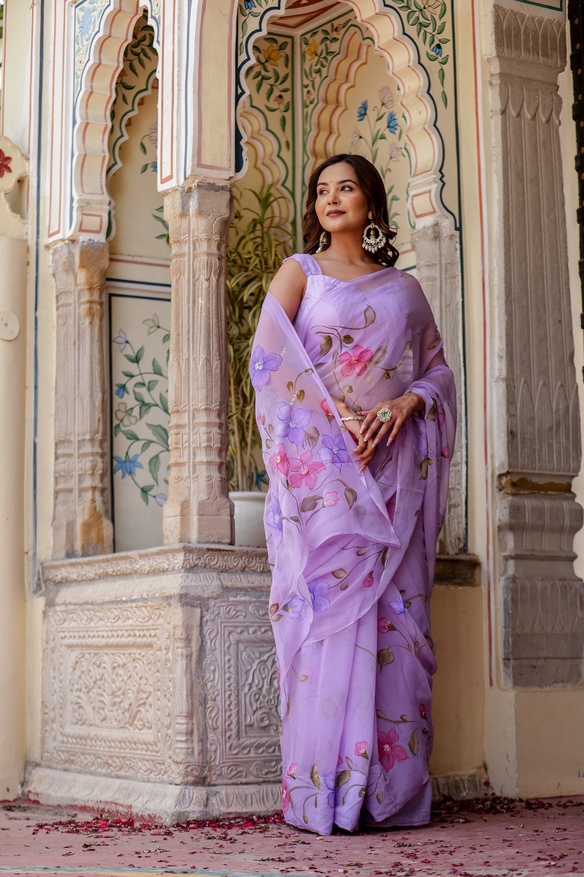 Elegant model wearing a handpainted lavender chiffon saree with floral designs, showcasing traditional style