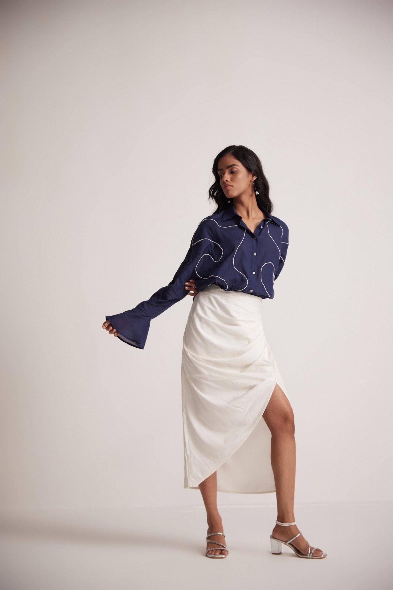 Stylera ivory white draped skirt styled with navy blue blouse and white heels