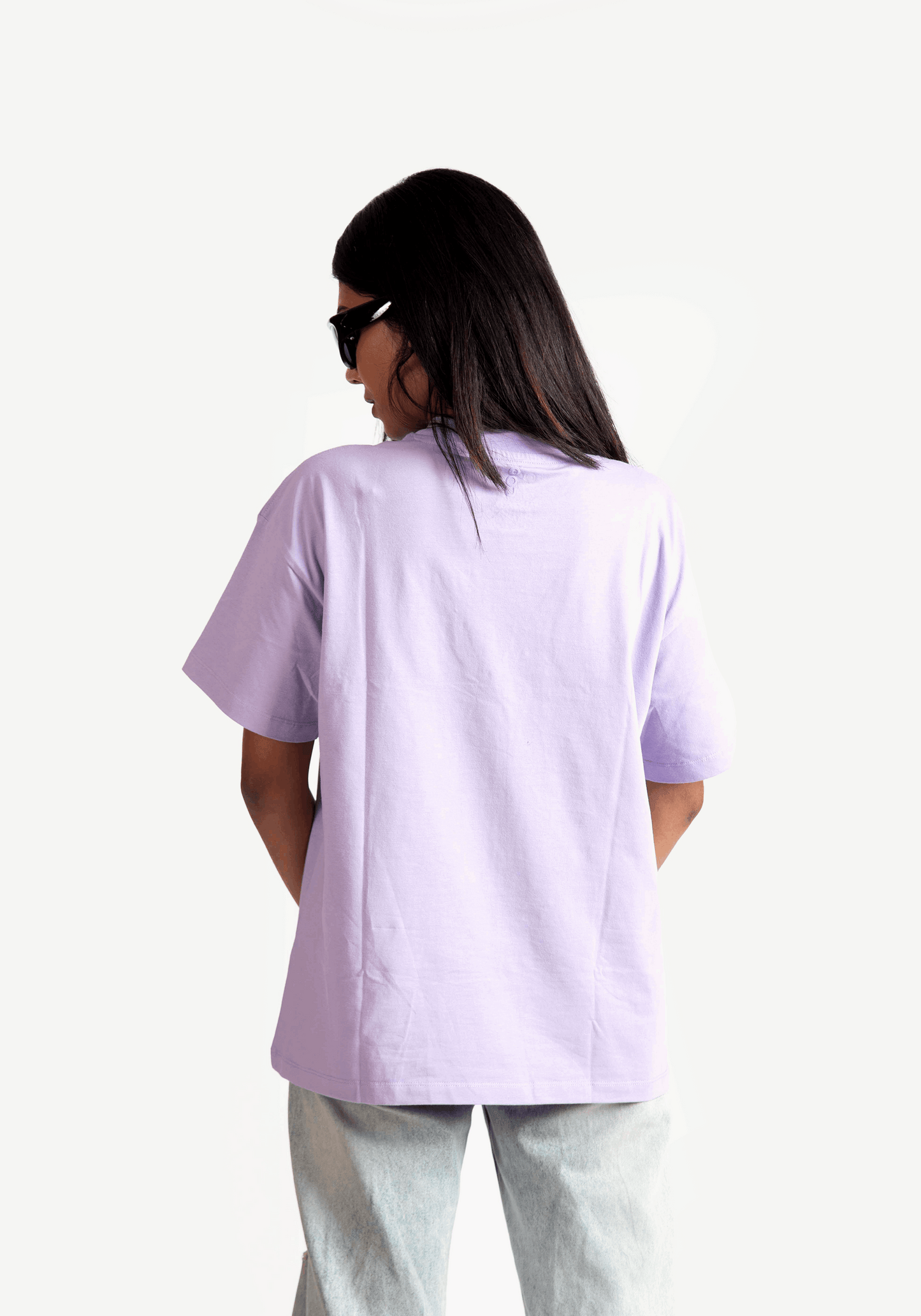 Back view of woman wearing Stylera lavender oversized t-shirt with light denim jeans