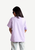 Back view of woman wearing Stylera lavender oversized t-shirt with light denim jeans