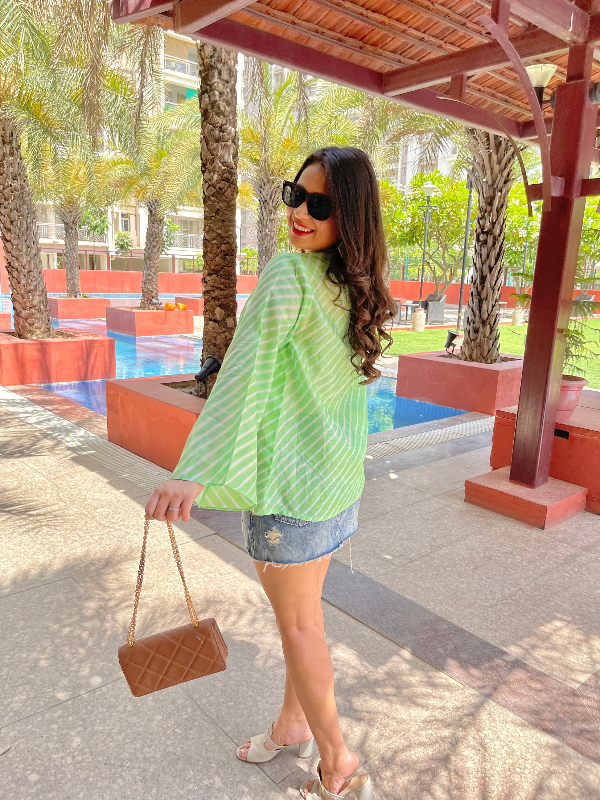 Stylish lehriya print summer tops for women in green paired with denim shorts and sunglasses