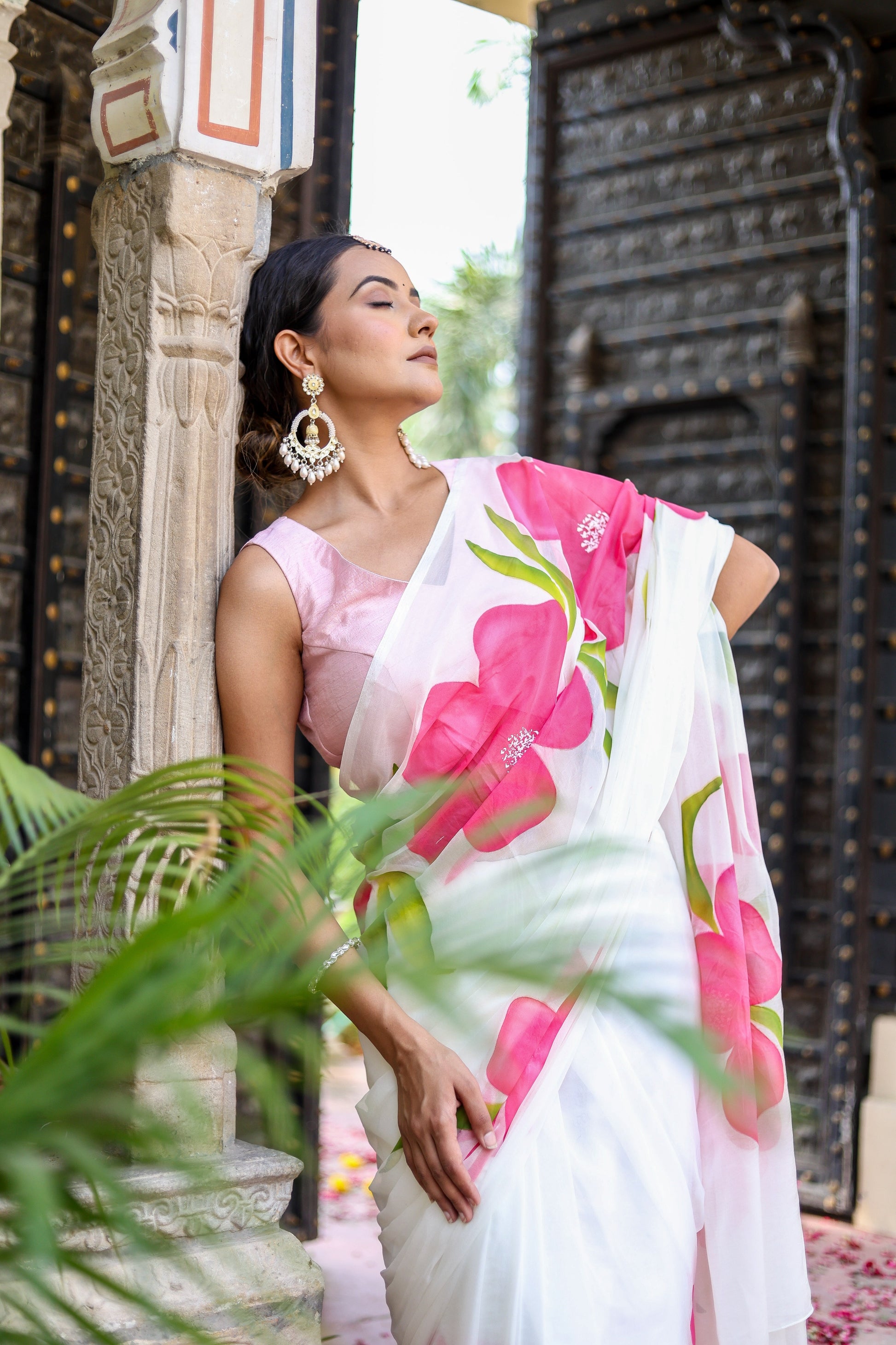 Elegant model in a lightweight party wear chiffon saree featuring pink floral patterns