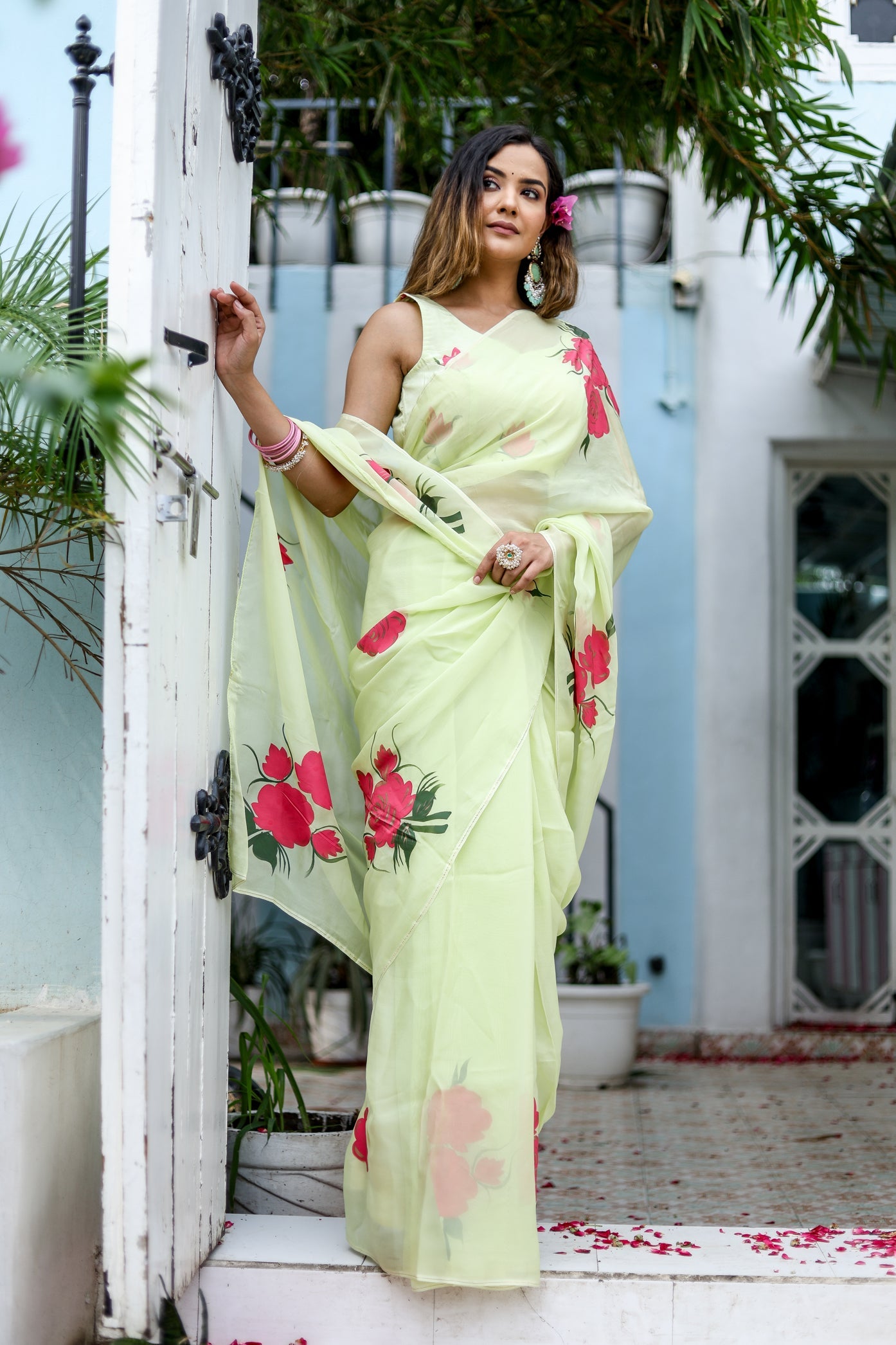 Elegant lightweight pastel saree with floral print, featuring pink flowers against a soft green background.