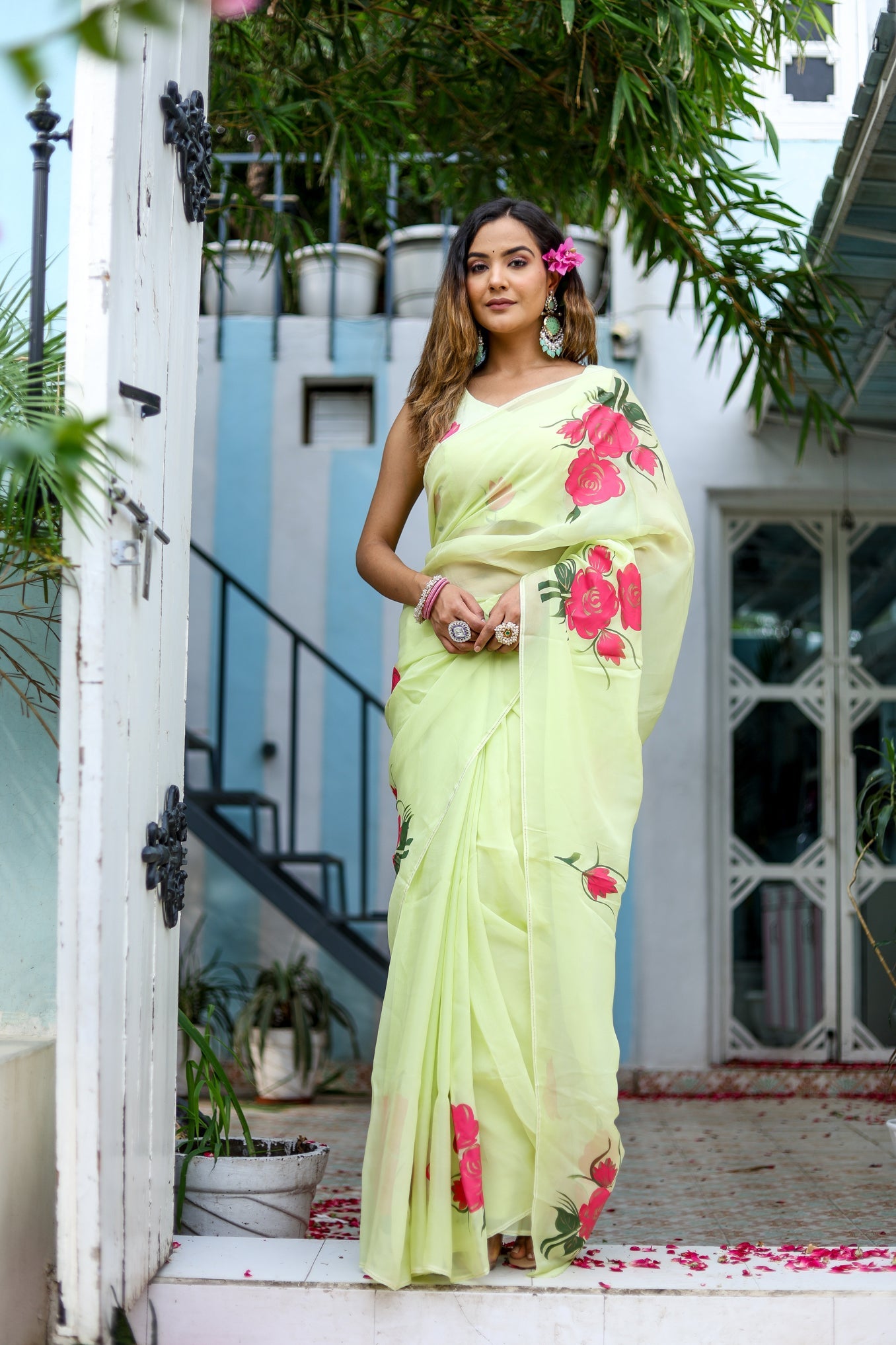 Model wearing a lightweight pastel saree with floral print, showcasing elegant draping and vibrant floral designs