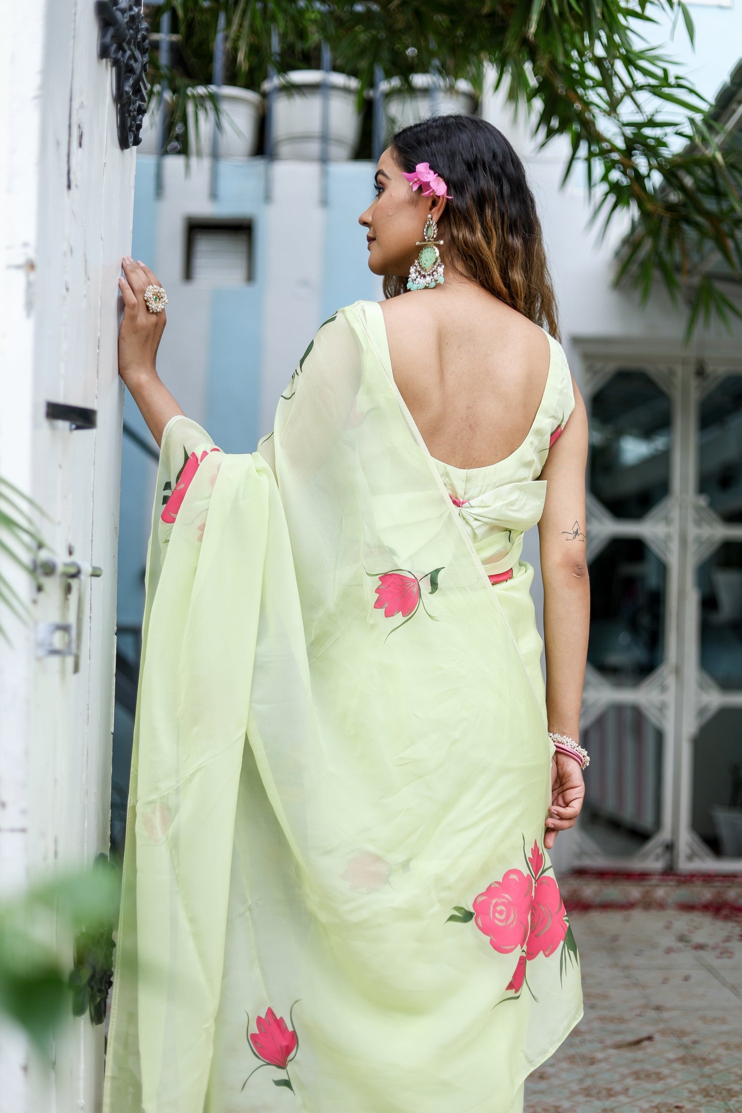 Stylish woman wearing a lightweight pastel saree with floral print in a serene outdoor setting
